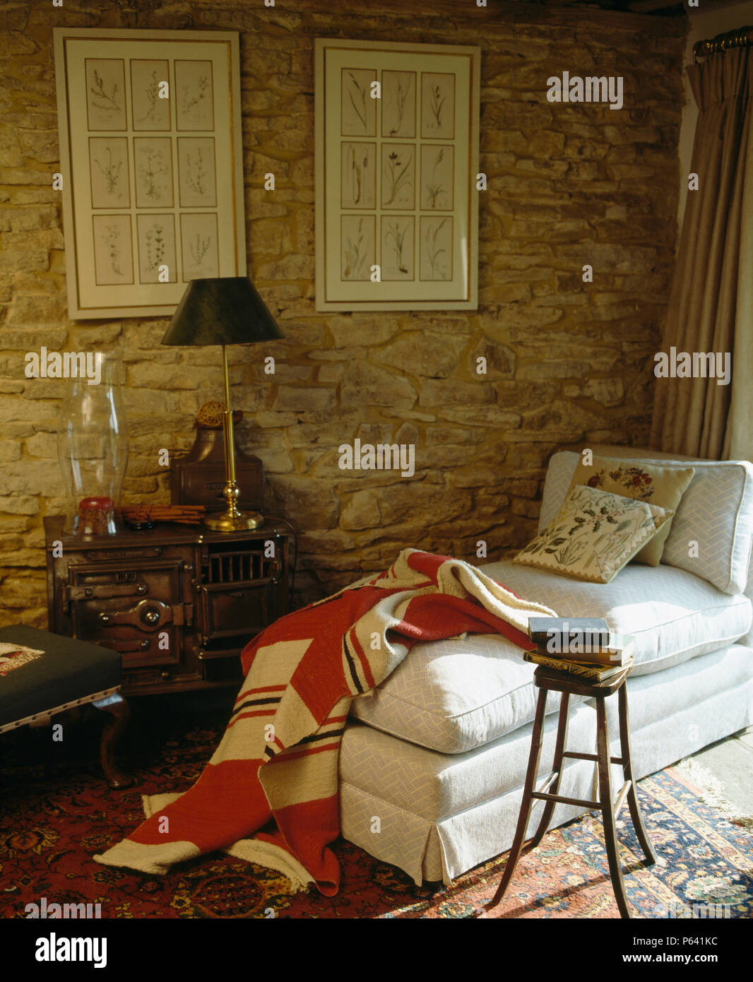 Red+cream quilted patchwork throw on white chaiselongue against exposed