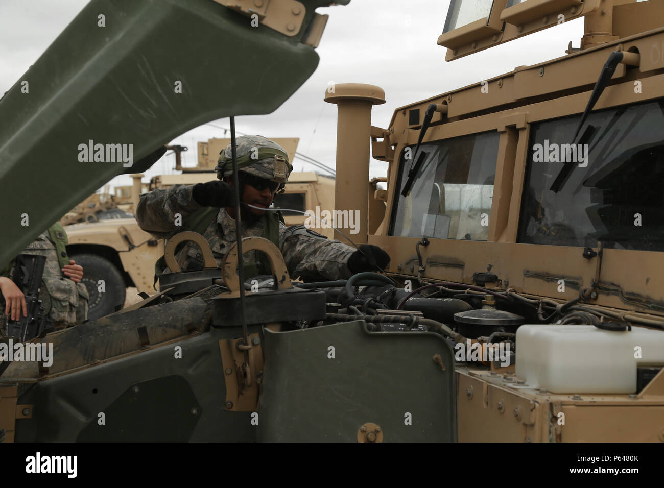 A U.S. Army Soldier assigned to 123rd Brigade Support Battalion 3rd Brigade Combat Team, 1st Armored Division, performs maintenance checks and services on a Humvee during Decisive Action Rotation 16-05 at the National Training Center at Fort Irwin, Calif., April 11, 2016. (U.S. Army Photo by Pfc. Esmeralda Cervantes, Released) Stock Photo