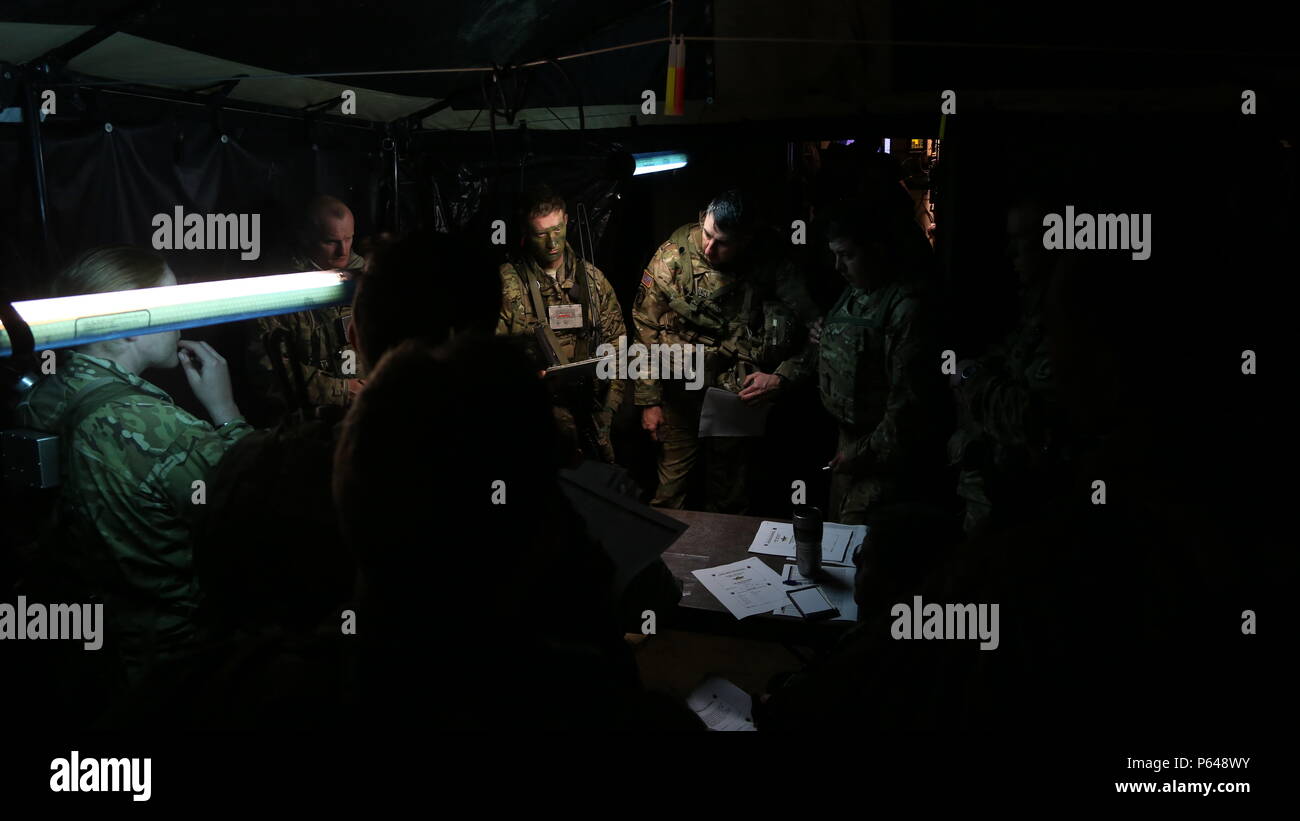 U.S. Soldiers of 3rd Battalion, 227th Aviation Regiment, 1st Air Cavalry Brigade and 173rd Airborne Brigade conduct an air mission brief during exercise Saber Junction 16 at the U.S. Army’s Joint Multinational Readiness Center (JMRC) in Hohenfels, Germany, April 17, 2016. Saber Junction 16 is the U.S. Army Europe’s 173rd Airborne Brigade’s combat training center certification exercise, taking place at the JMRC in Hohenfels, Germany, Mar. 31-Apr. 24, 2016.  The exercise is designed to evaluate the readiness of the Army’s Europe-based combat brigades to conduct unified land operations and promot Stock Photo
