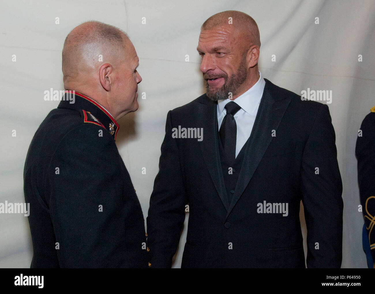 U.S. Marine Corps Gen. Robert B. Neller, 37th Commandant of the Marine Corps, speaks with Paul M. Levesque “Triple H”, American professional wrestler, during the reception before the United Service Organizations (USO) of Metropolitan Washington Annual Gala in Arlington, Va., April 19, 2016. The Gala was held in honor of the 75th Anniversary of the Metropolitan Washington USO.  (U.S. Marine Corps photo by Lance Cpl. Hailey D. Stuart/Released) Stock Photo
