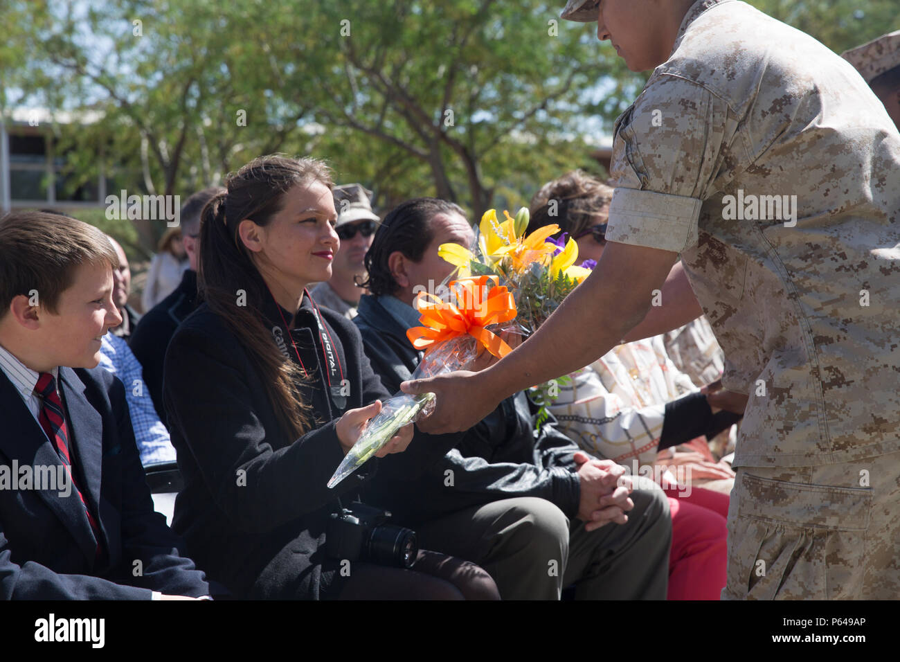 Katherine Kennedy, daughter of Col. Andrew R. Kennedy, former director of Tactical Training and Exercise Control Group, is presented flowers during her father’s retirement ceremony at Lance Cpl. Torrey L. Gray Field April 15, 2016. (Official Marine Corps photo by Cpl. Medina Ayala-Lo/Released) Stock Photo