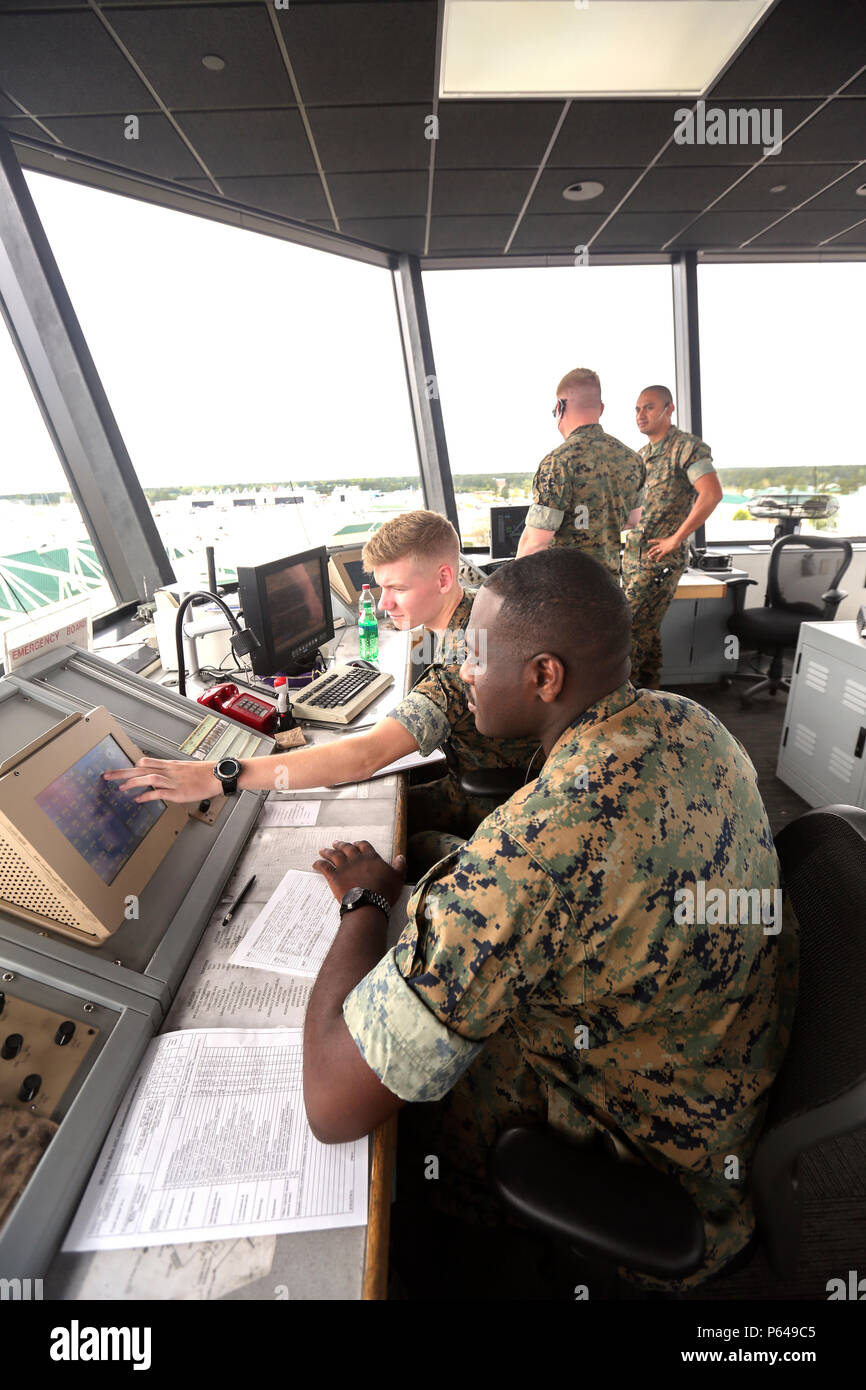 Marines with air traffic control, look over the flightline at the air traffic control tower on Marine Corps Air Station New River April 15. Air traffic control maintains the safe, orderly and expeditious flow of air traffic. Stock Photo