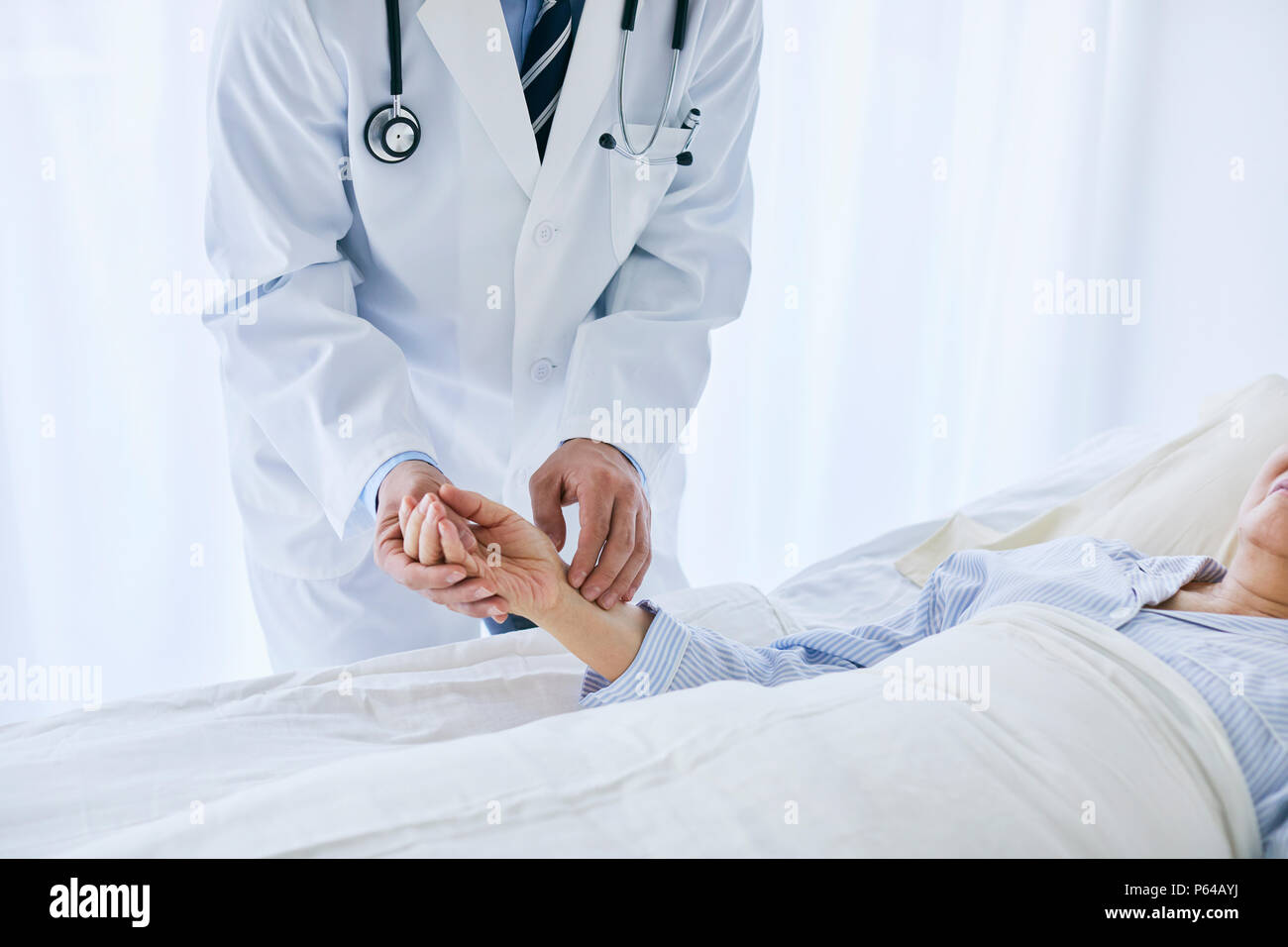 Japanese doctor with a patient in bed Stock Photo - Alamy