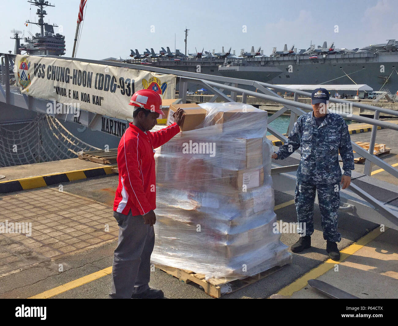 SINGAPORE (Apr. 21, 2016) – LS1 Joseph Lejos (right), Naval Supply Systems Command Fleet Logistics Center Yokosuka, Site Singapore (FLC), supervises the delivery of supply items to ships belonging to the USS John C. Stennis (CVN 74) Carrier Strike Group Apr. 21, 2016. Navy Region Center Singapore (NRCS) welcomed Sailors from the strike group during a port visit in Sembawang, Singapore, April 19-23, 2016. The FLC logistics team coordinates with supply officers onboard ships prior to their arrival in order to provide quality logistics services such as provisions, fuel, postal services, and pier- Stock Photo