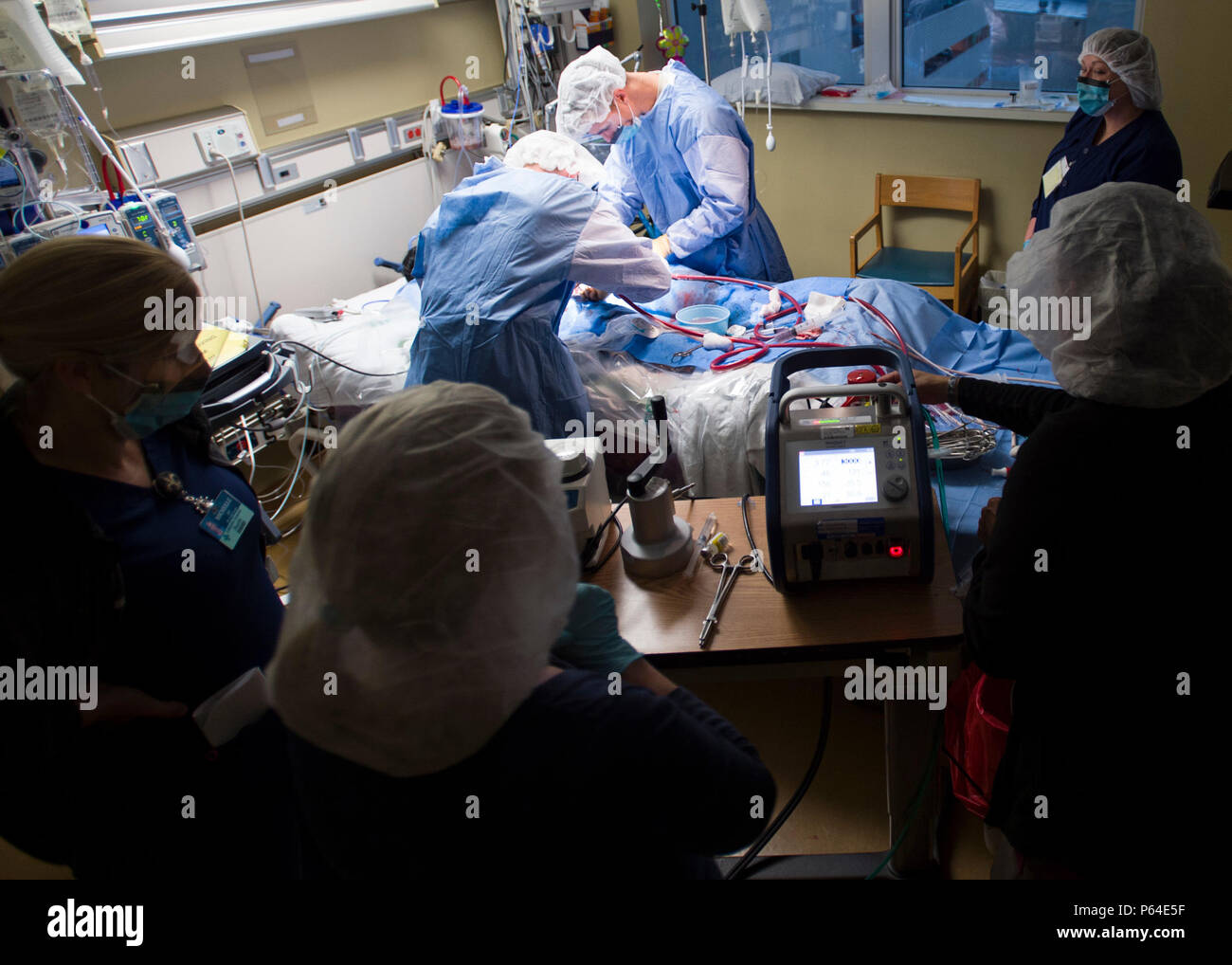 Members of the 59th Medical Wing Extracorporeal Membrane Oxygenation transport team connect a patient to an ECMO system for transport from Lafayette General Medical Center to San Antonio Military Medical Center, Joint Base San Antonio-Fort Sam Houston, Texas, April 20. ECMO is a heart-lung bypass system that circulates blood through an external artificial lung and sends it back into the patient’s bloodstream. Stock Photo