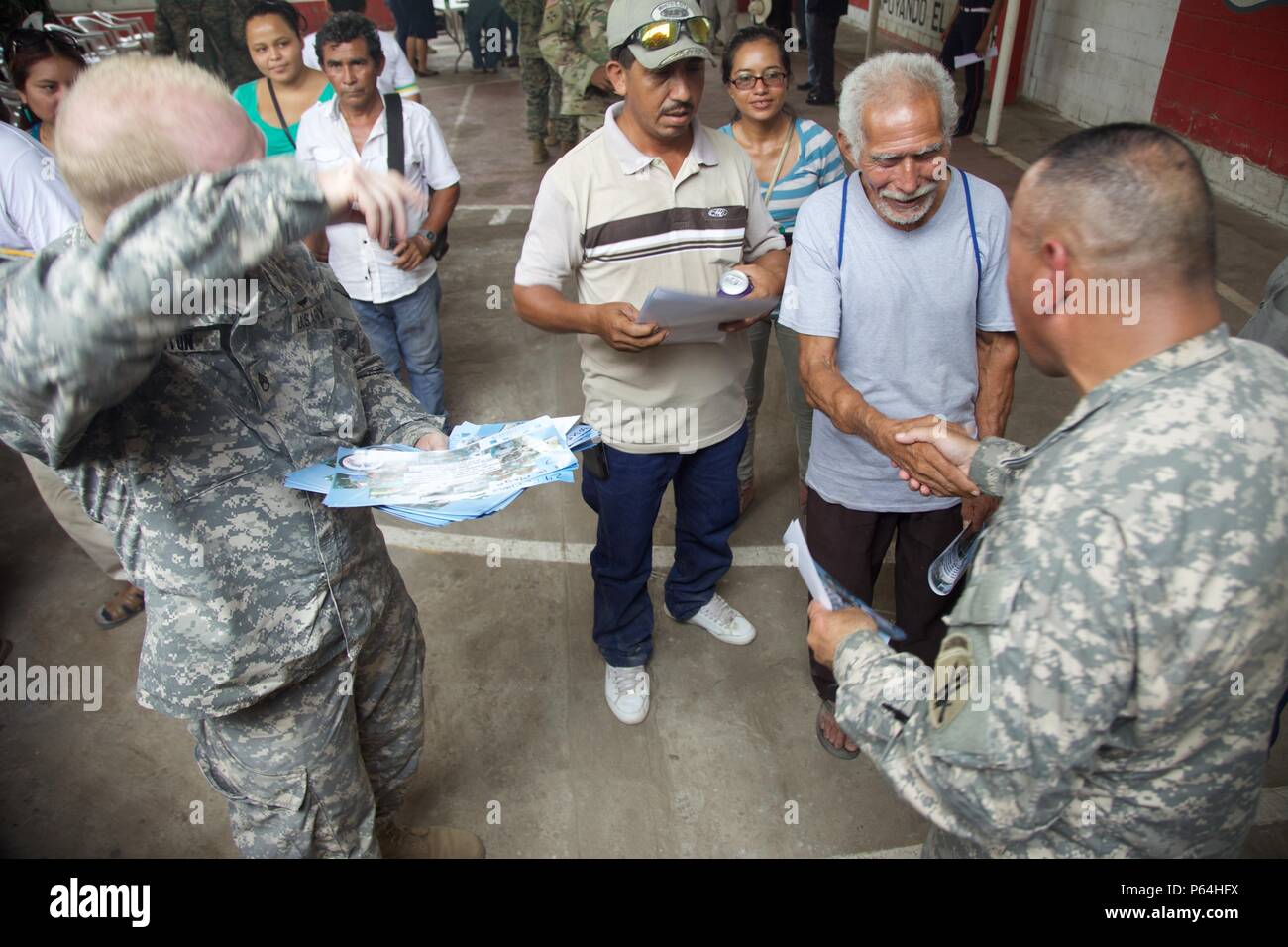 Sgt. 1st Class Luis Villarreal gives posters to the local Cocodes to advertise a future Medical Treatment Exercise as part of the Beyond The Horizon Operation at San Pedro, Guatemala, May 04, 2016. Task Force Red Wolf and Army South conducts Humanitarian Civil Assistance Training to include tactical level construction projects and Medical Readiness Training Exercises providing medical access and building schools in Guatemala with the Guatemalan Government and non-government agencies from 05MAR16 to 18JUN16 in order to improve the mission readiness of US forces and to provide a lasting benefit  Stock Photo