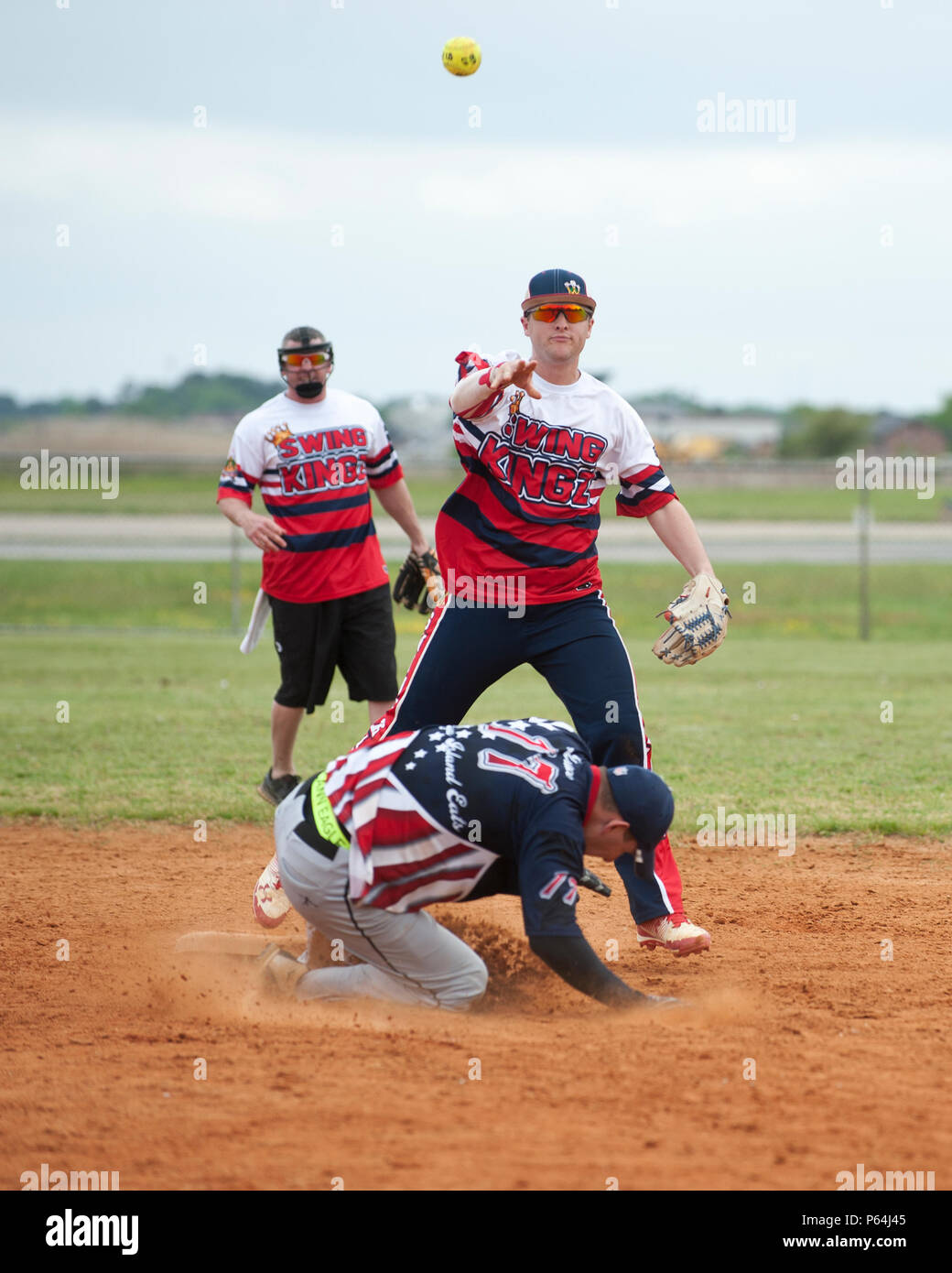 A member of the Swing Kingz softball team throws the ball to first base