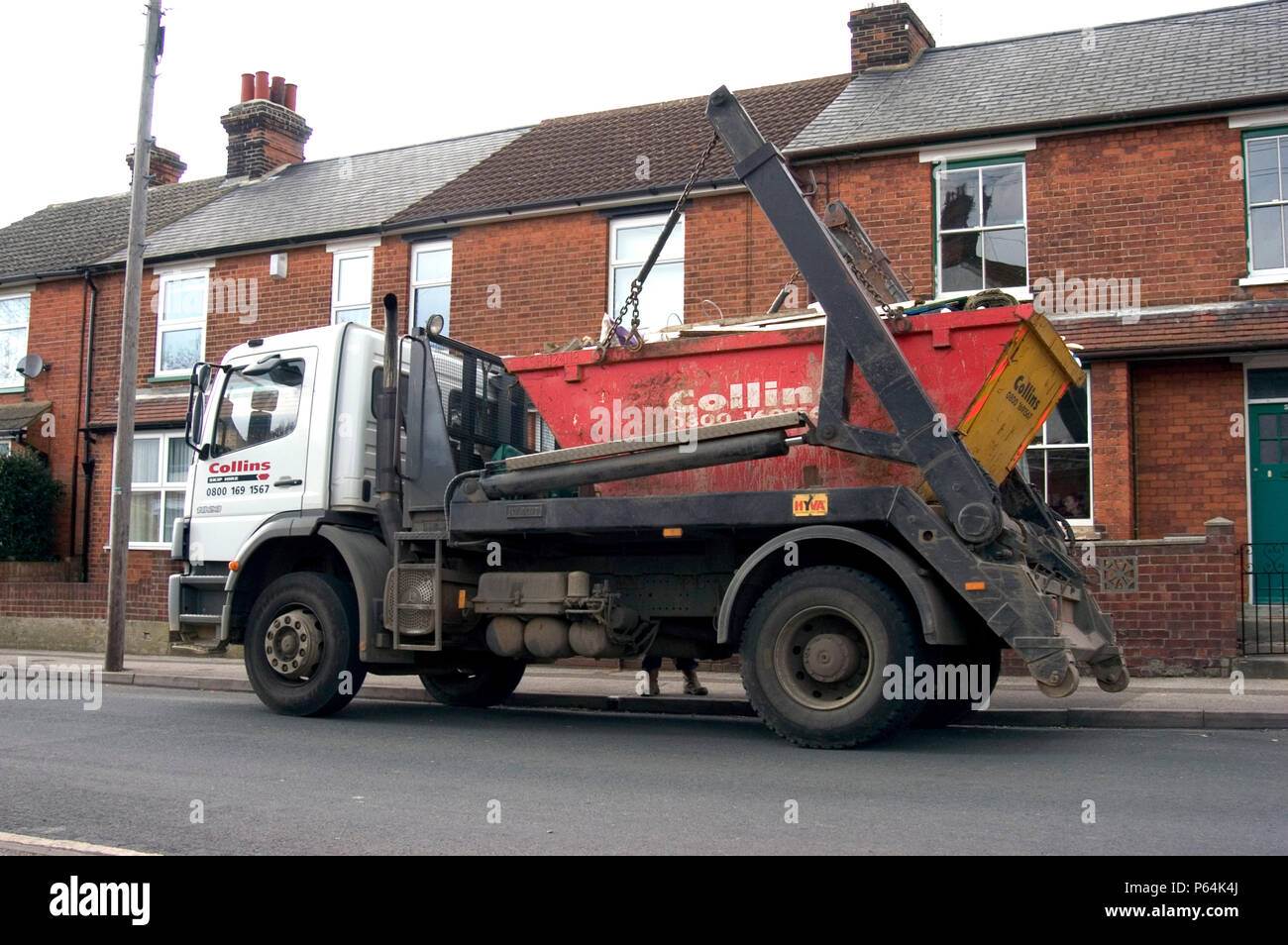 Skip loader collecting a skip Stock Photo Alamy