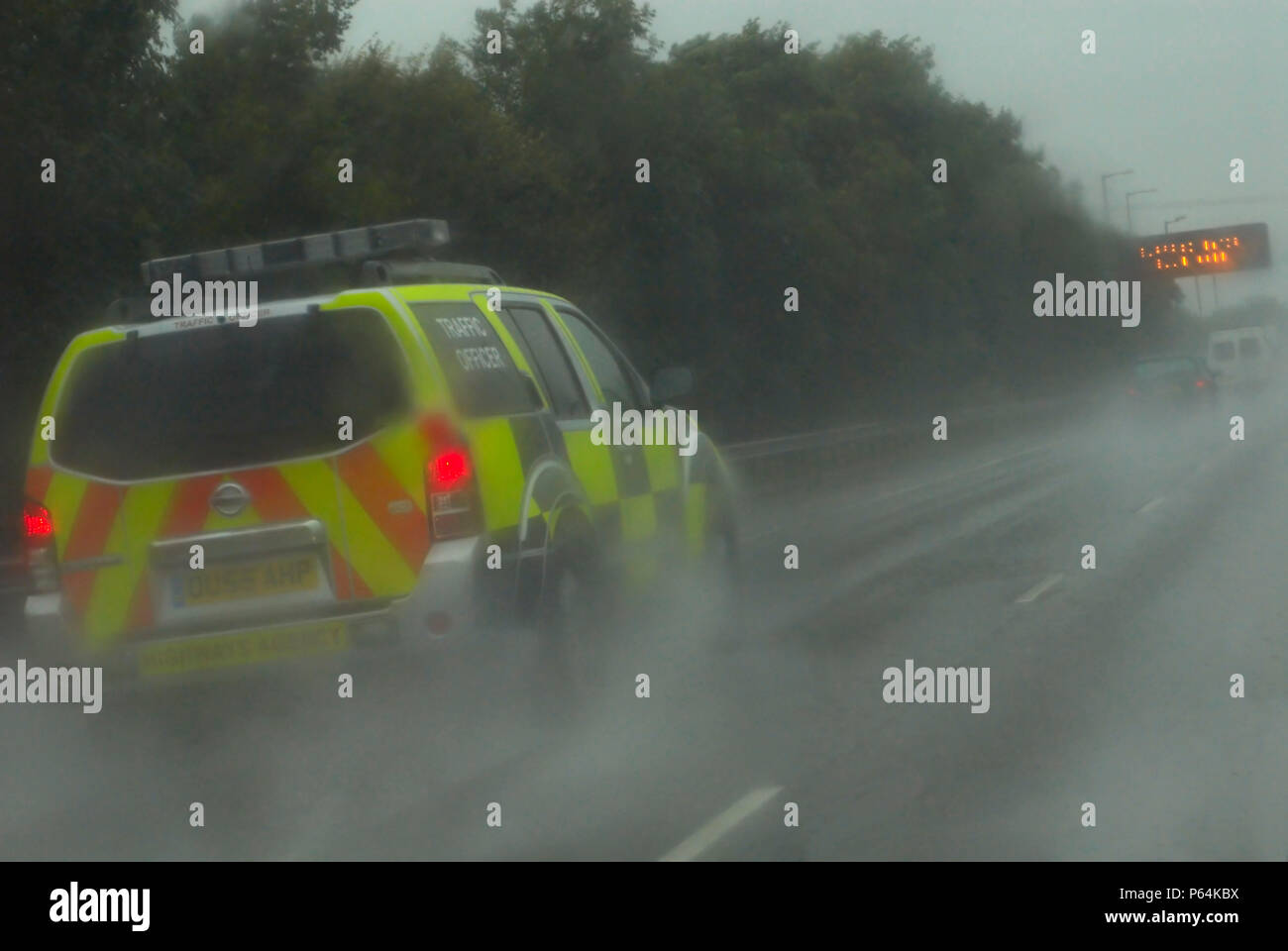 Traffic police vehicle in poor wet driving conditions on the M6 motorway, UK Stock Photo