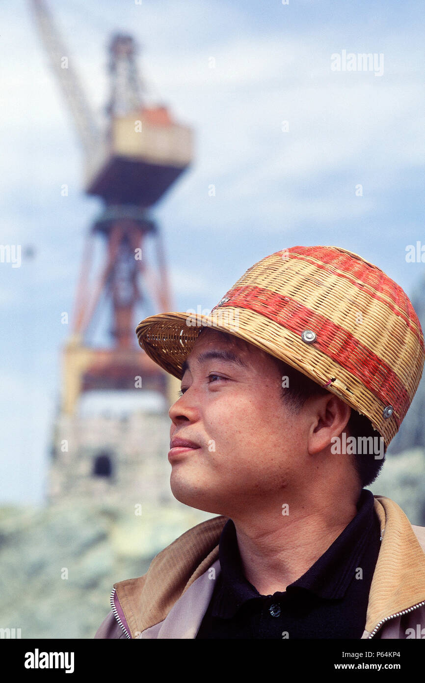 Chinese site worker wearing bamboo hard hat. Three Gorges Dam, Yangtse River. Sandouping, Yichang, Hubei Province, China. Stock Photo