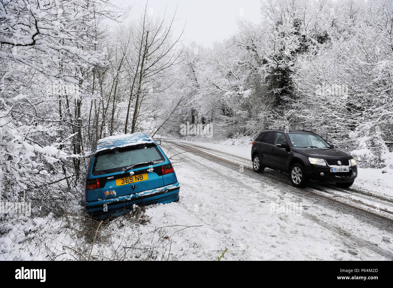 Abandoned car by side of road in snowy weather, UK Stock Photo