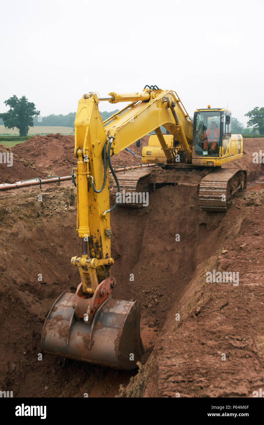 Murphy pipeline project laying gas pipe from Tirley in Gloucestershire to Brecon, Powys, A mechnical digger cuts the trench before lowering the pipe Stock Photo