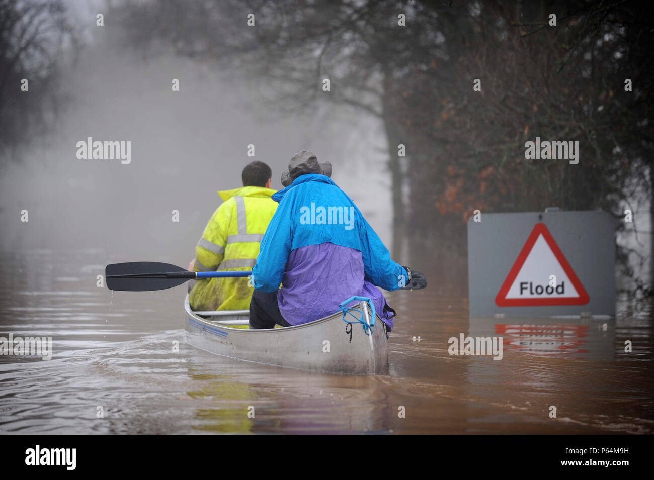 Two people canoeing past flood sign during floods, Gloucestershire, UK, 2007 Stock Photo