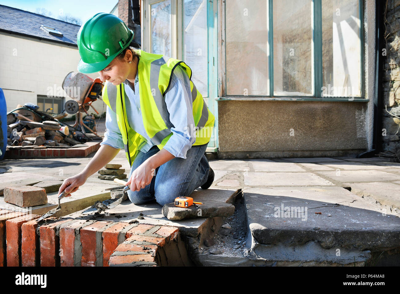Woman pointing in the edging bricks of patio, UK Stock Photo Alamy