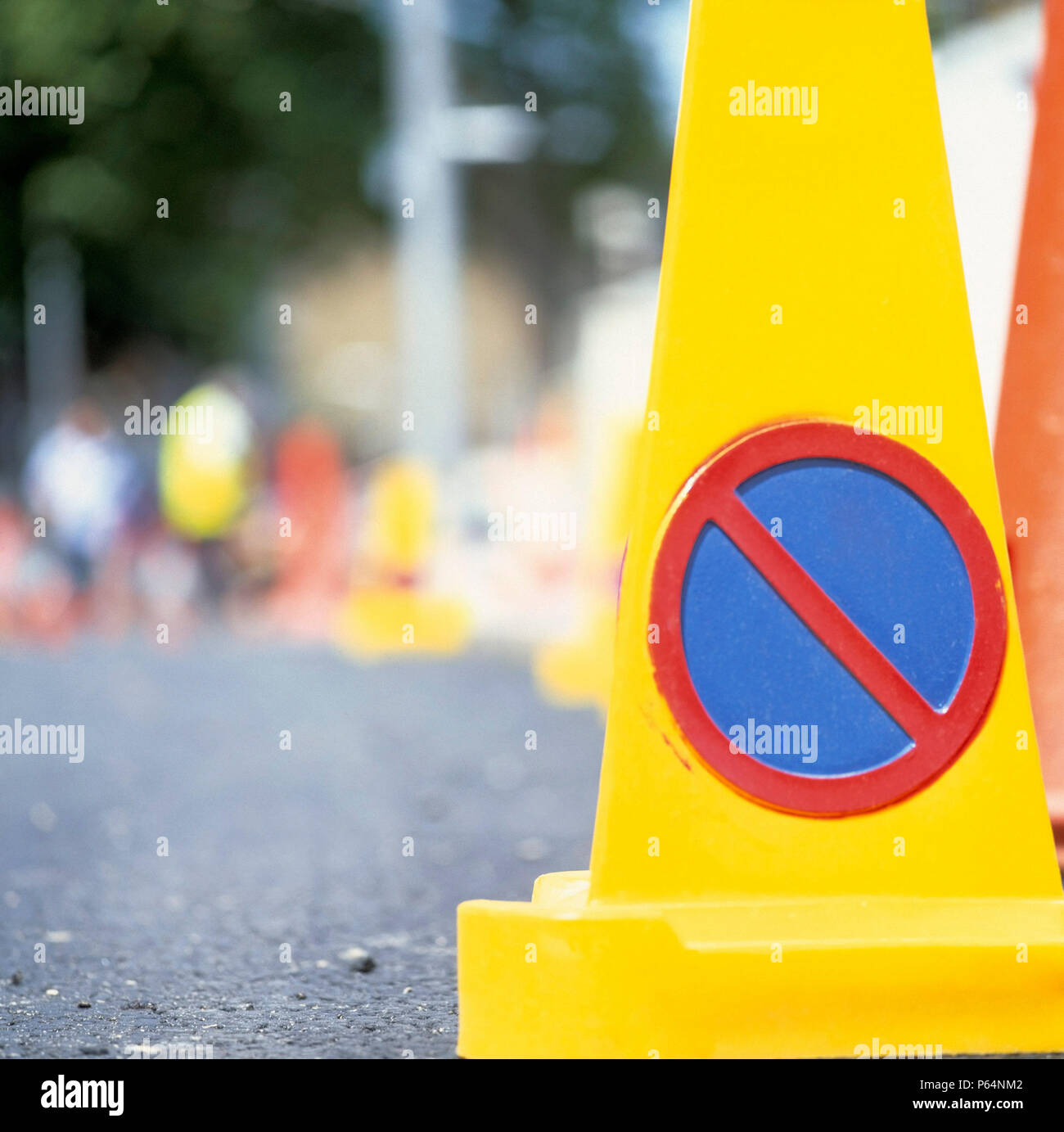 Yellow traffic cone with more cones softly going into distance Stock