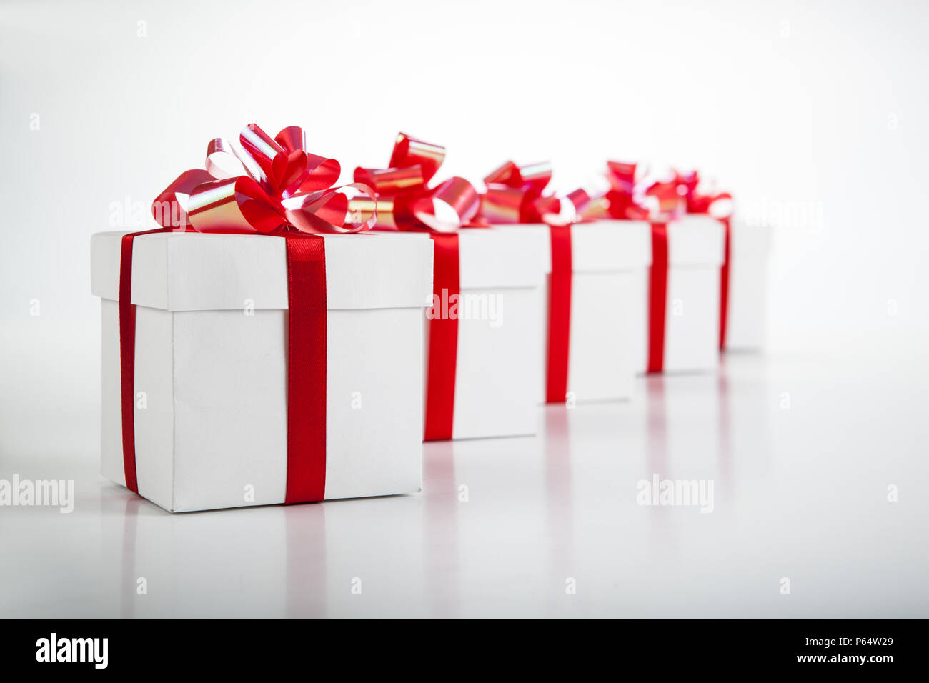 White gift boxes with red ribbons and bows on gray Stock Photo Alamy