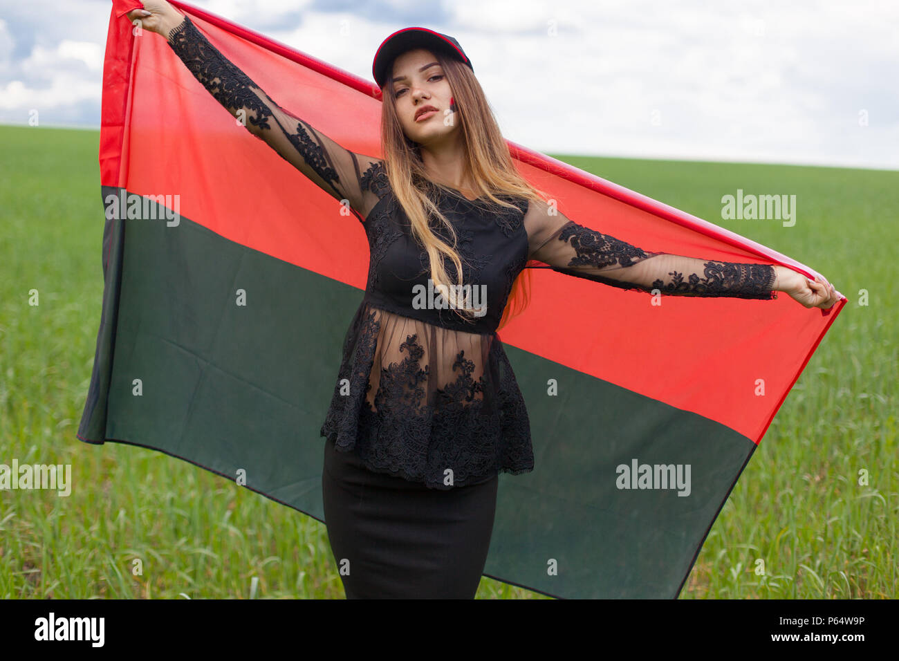 young beautiful ukrainian girl with an excellent figure in a black short  dress holds a national Ukrainian red black flag Stock Photo - Alamy