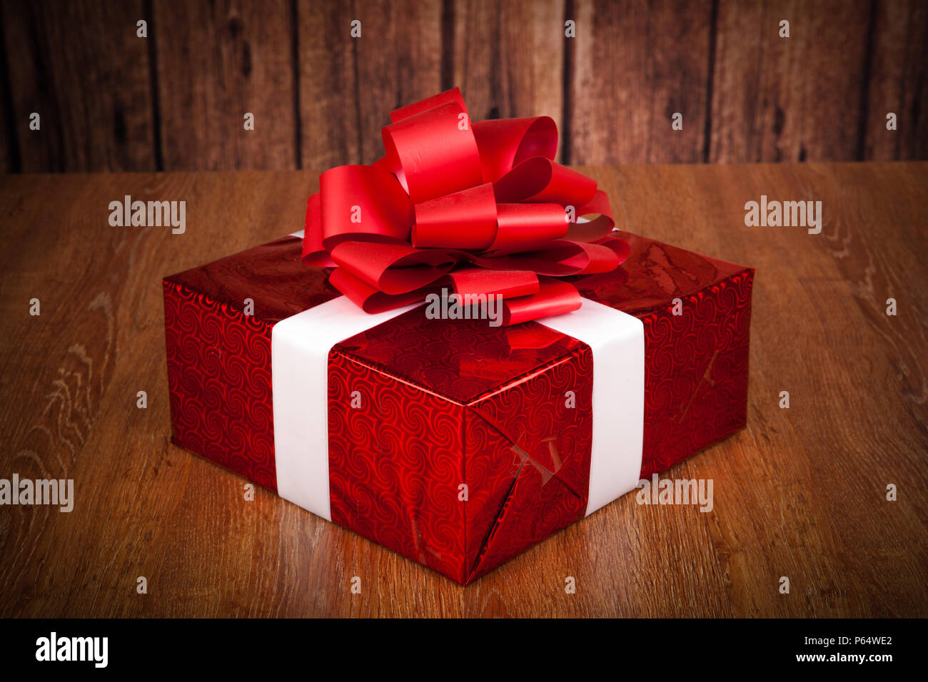 one large red gift box on a wood background Stock Photo - Alamy