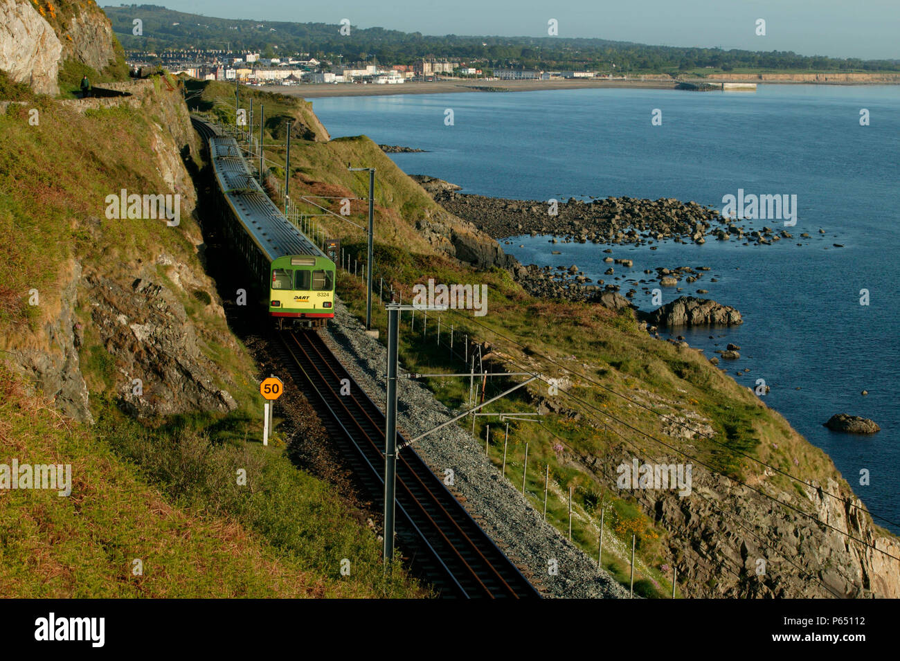 A Dublin Area Rapid Transit (DART) EMU threads its way southwards along the spectacular clifftop section between Bray and Greystones. Stock Photo