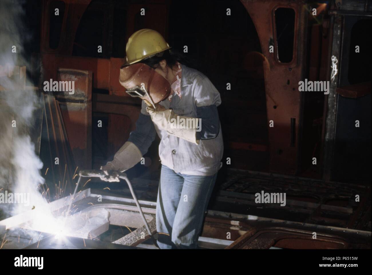 A girl welding detail parts for the building of SY Class 2-8-2s at Tangshan Locomotive Works China. Stock Photo