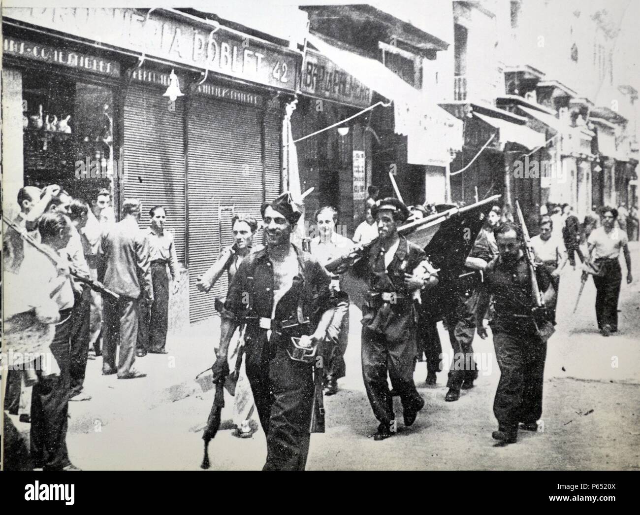 Enthusiastic republican fighters carry a captured flag during the Spanish civil war, Barcelona 1937 Stock Photo