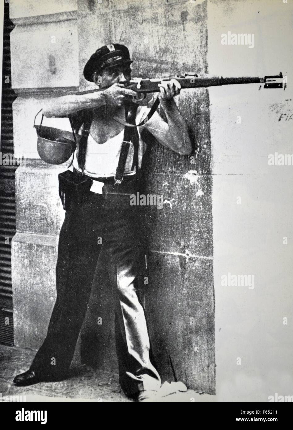 A republican marksman soldier takes shelter behind a street corner during the Spanish civil war, Barcelona 1936 Stock Photo