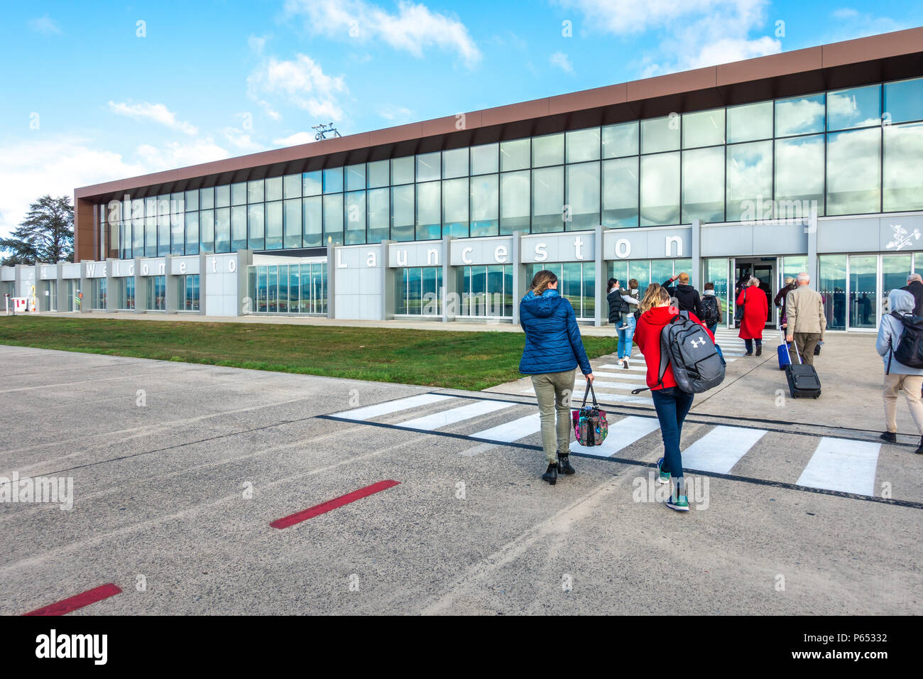 Passengers that just disembarked from aeroplane walking to arrival hall at Launceston airport. Tasmania, Australia. Stock Photo