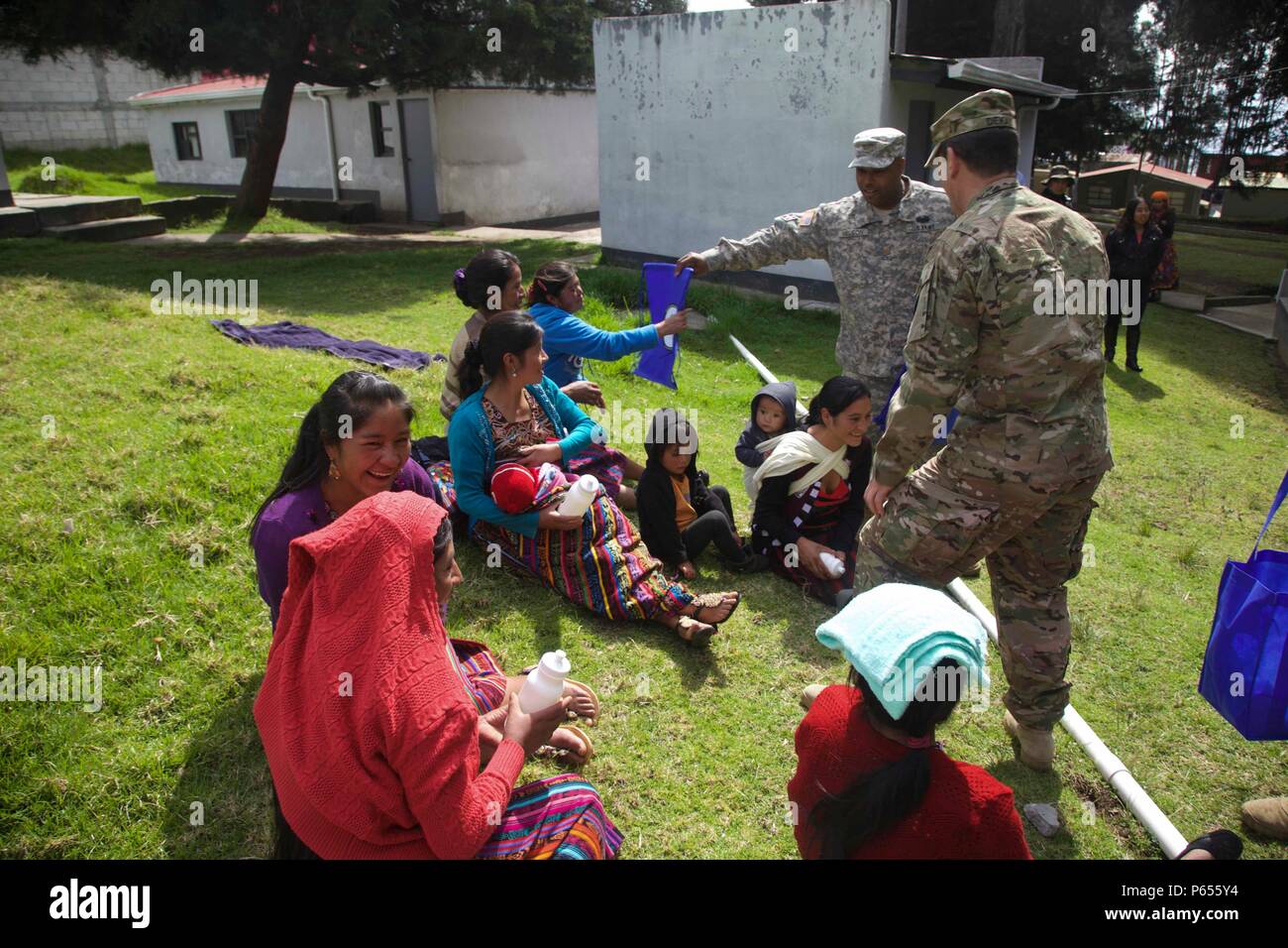 U.S. Army Soldiers give bags and water bottles to Guatemalan citizens to show comradery between the two partner nations and to promote the future medical treatment sites at San Marcos, Guatemala, April 30, 2016. Task Force Red Wolf and Army South conducts Humanitarian Civil Assistance Training to include tactical level construction projects and Medical Readiness Training Exercises providing medical access and building schools in Guatemala with the Guatemalan Government and non-government agencies from 05MAR16 to 18JUN16 in order to improve the mission readiness of US forces and to provide a la Stock Photo