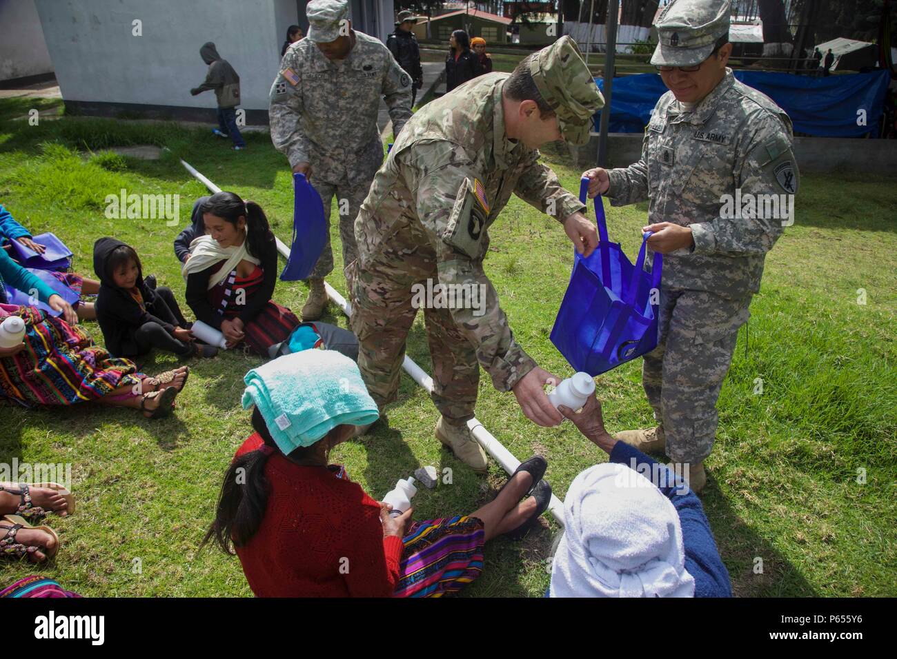 U.S. Army Soldiers give bags and water bottles to Guatemalan citizens to show comradery between the two partner nations and to promote the future medical treatment sites at San Marcos, Guatemala, April 30, 2016. Task Force Red Wolf and Army South conducts Humanitarian Civil Assistance Training to include tactical level construction projects and Medical Readiness Training Exercises providing medical access and building schools in Guatemala with the Guatemalan Government and non-government agencies from 05MAR16 to 18JUN16 in order to improve the mission readiness of US forces and to provide a la Stock Photo