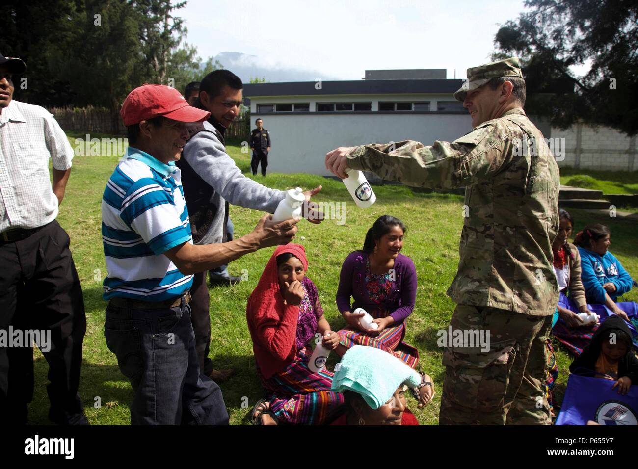 U.S. Army Staff Sgt. Brandon Hudgins gives bags and water bottles to Guatemalan citizens to show comradery between the two partner nations and to promote the future medical treatment sites at San Marcos, Guatemala, April 30, 2016. Task Force Red Wolf and Army South conducts Humanitarian Civil Assistance Training to include tactical level construction projects and Medical Readiness Training Exercises providing medical access and building schools in Guatemala with the Guatemalan Government and non-government agencies from 05MAR16 to 18JUN16 in order to improve the mission readiness of US forces  Stock Photo