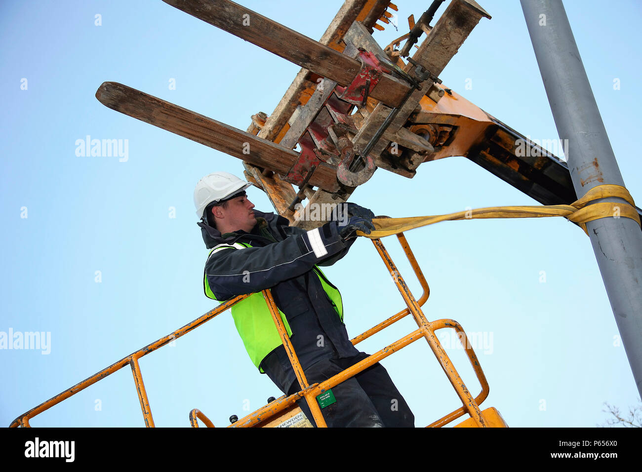 Telescopic forklift lifting streetlight into position Stock Photo Alamy