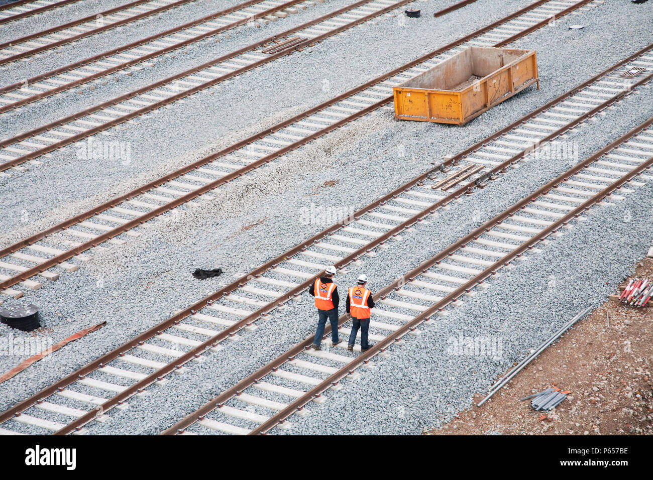 Construction workers walk along newly laid tracks at the New Cross Gate Depot in South London, which will serve the extended London Overground East Lo Stock Photo