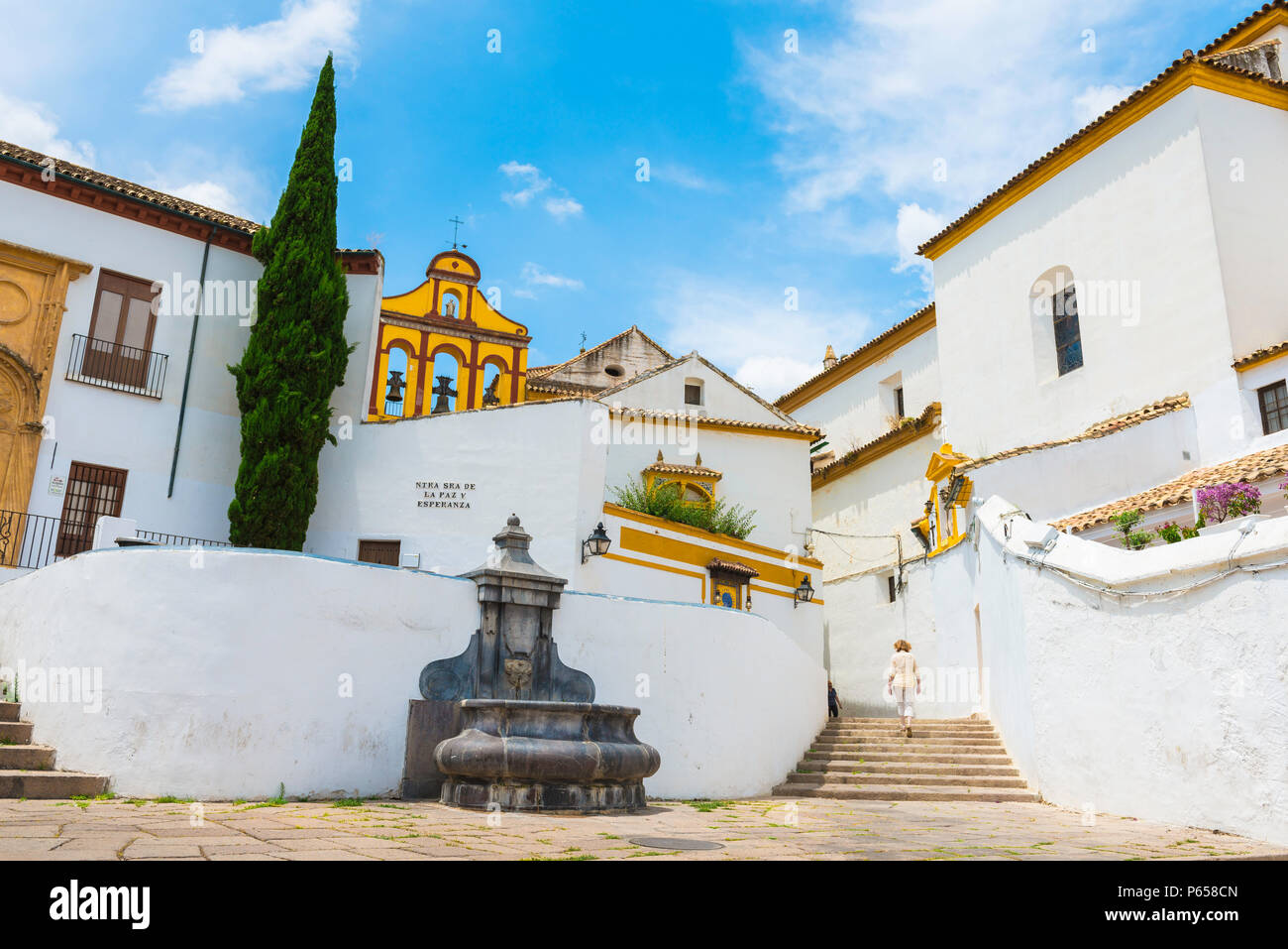 Andalucia Spain city, a woman walks through a section of the old town in Cordoba containing typical white Andalucian buildings, Andalucia Spain. Stock Photo
