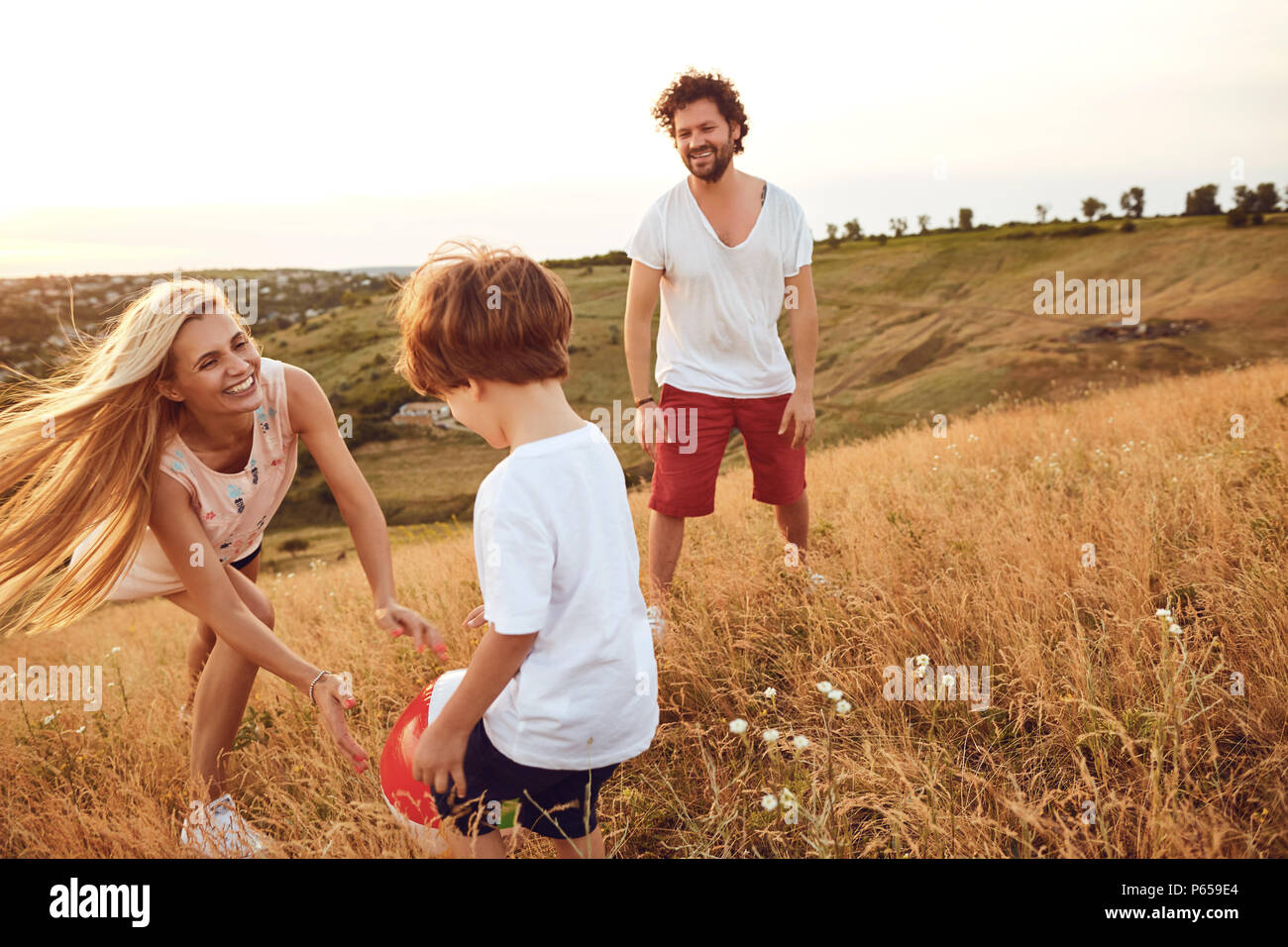 Happy family having fun playing at sunset in nature. Stock Photo