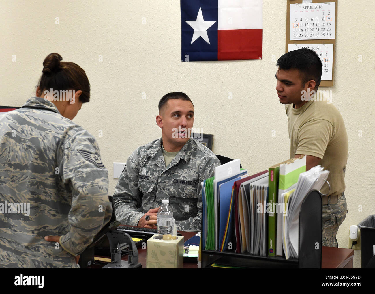 Staff Sgt. John B. Solano (center), military pay technician, visits with  Tech. Sgt. Veronica Herrada (left), commander support staff, a member of  the 149th Fighter Wing (right), at Luke Air Force Base,