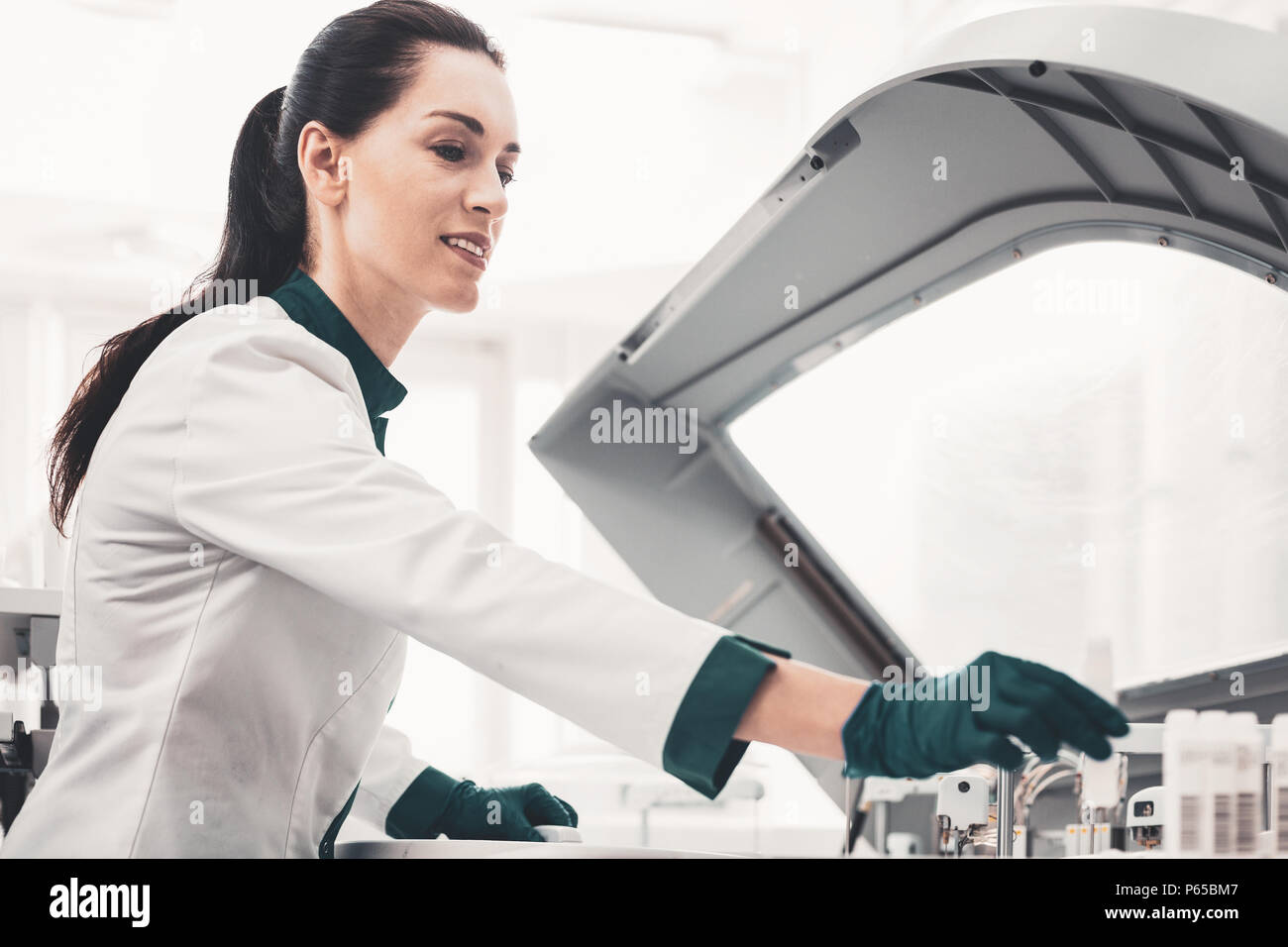 Pleased laboratory scientist putting test tubes in order Stock Photo