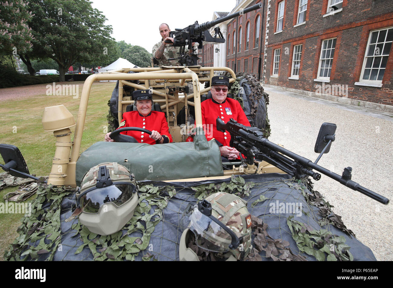 Chelsea pensioners Monica Parrott (left), who drove Land Rover vehicles in the Women's Royal Army Corps between 1964-1966 whilst stationed in Aldershot, and Dougie May (right), former Platoon Commander in the 1st Battalion, The Royal Anglian Regiment with Trooper Dean Clark, 7th Infantry Brigade in an armoured Land Rover WMIK (Weapons Mounted Installation Kit) at the Royal Hospital Chelsea in London ahead of Armed Forces Day on June 30th. Stock Photo