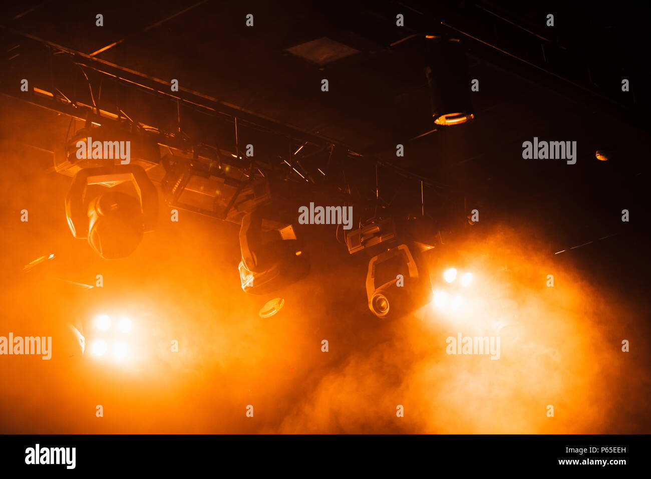 Red strobe lights with strong beams in smoke over dark background