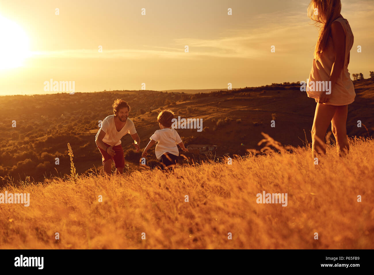 Happy family having fun playing at sunset. Stock Photo
