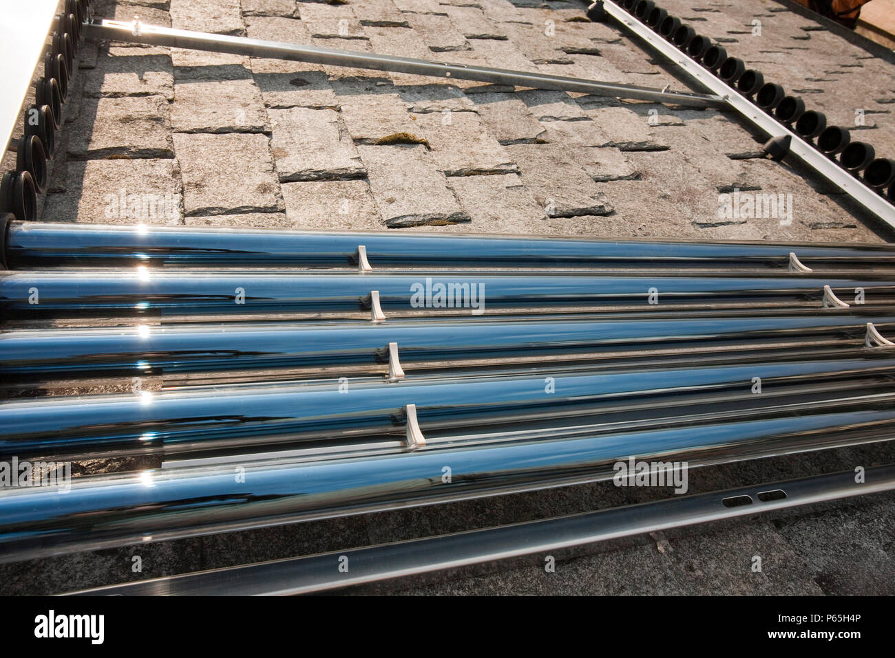 A solar water heating panel being fitted to a house roof in Ambleside, Cumbria, UK Stock Photo