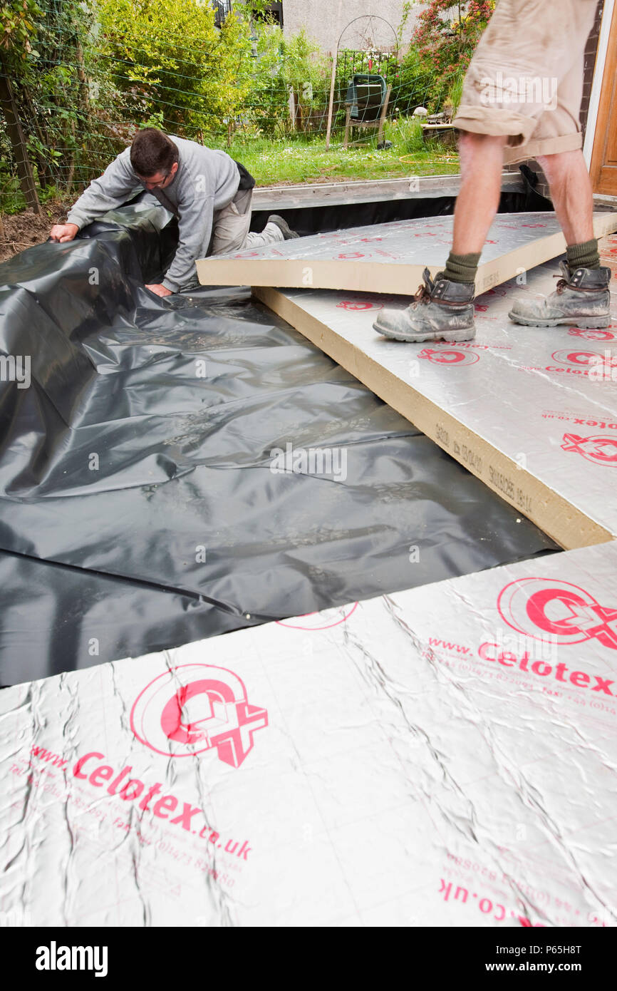 Builders lay under floor insulation into a house extension in Ambleside, UK. Stock Photo