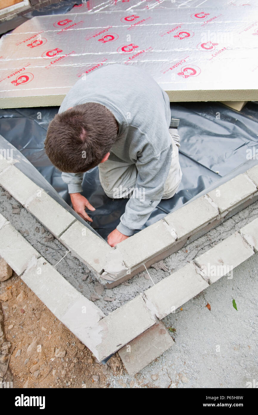 Builders lay under floor insulation into a house extension in Ambleside, UK. Stock Photo