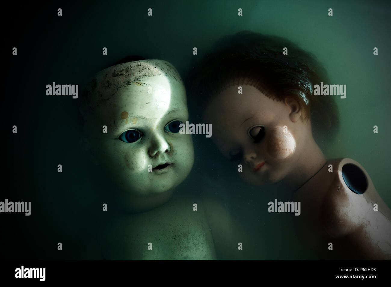 Creepy dolls in dark dirty water Stock Photo