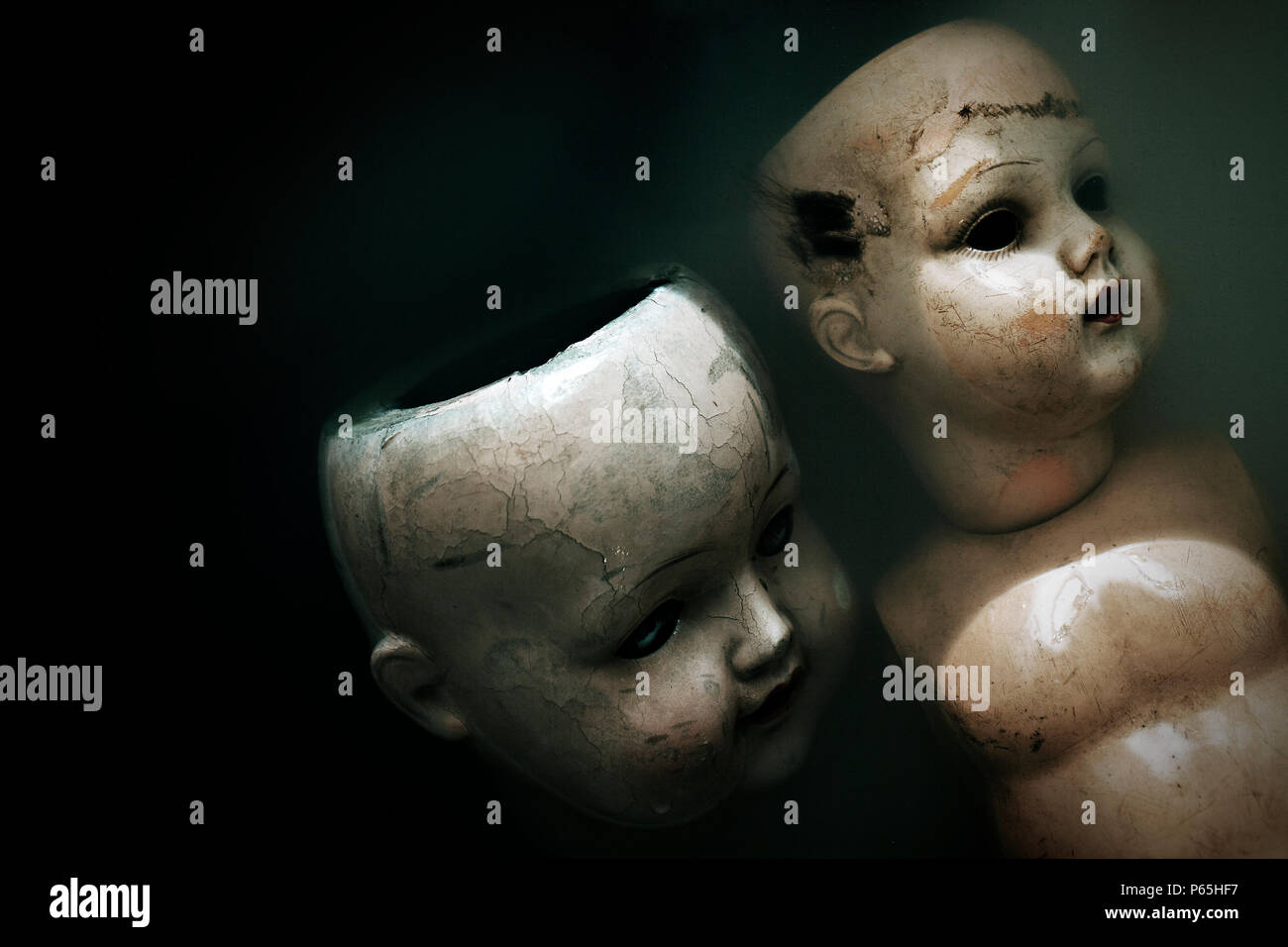 Creepy dolls in dark dirty water Stock Photo