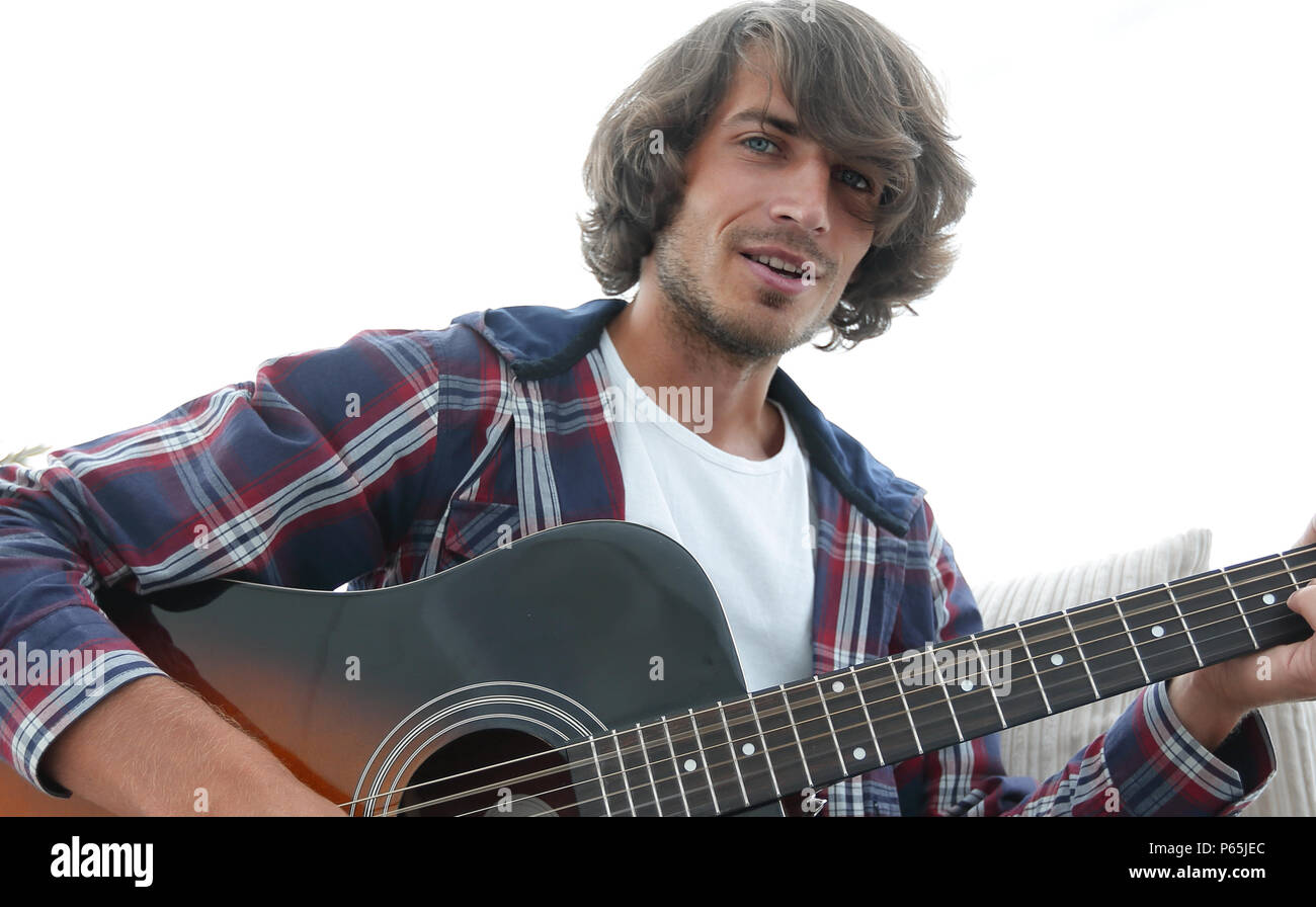 guy sings a song and plays guitar sitting on the couch Stock Photo Alamy