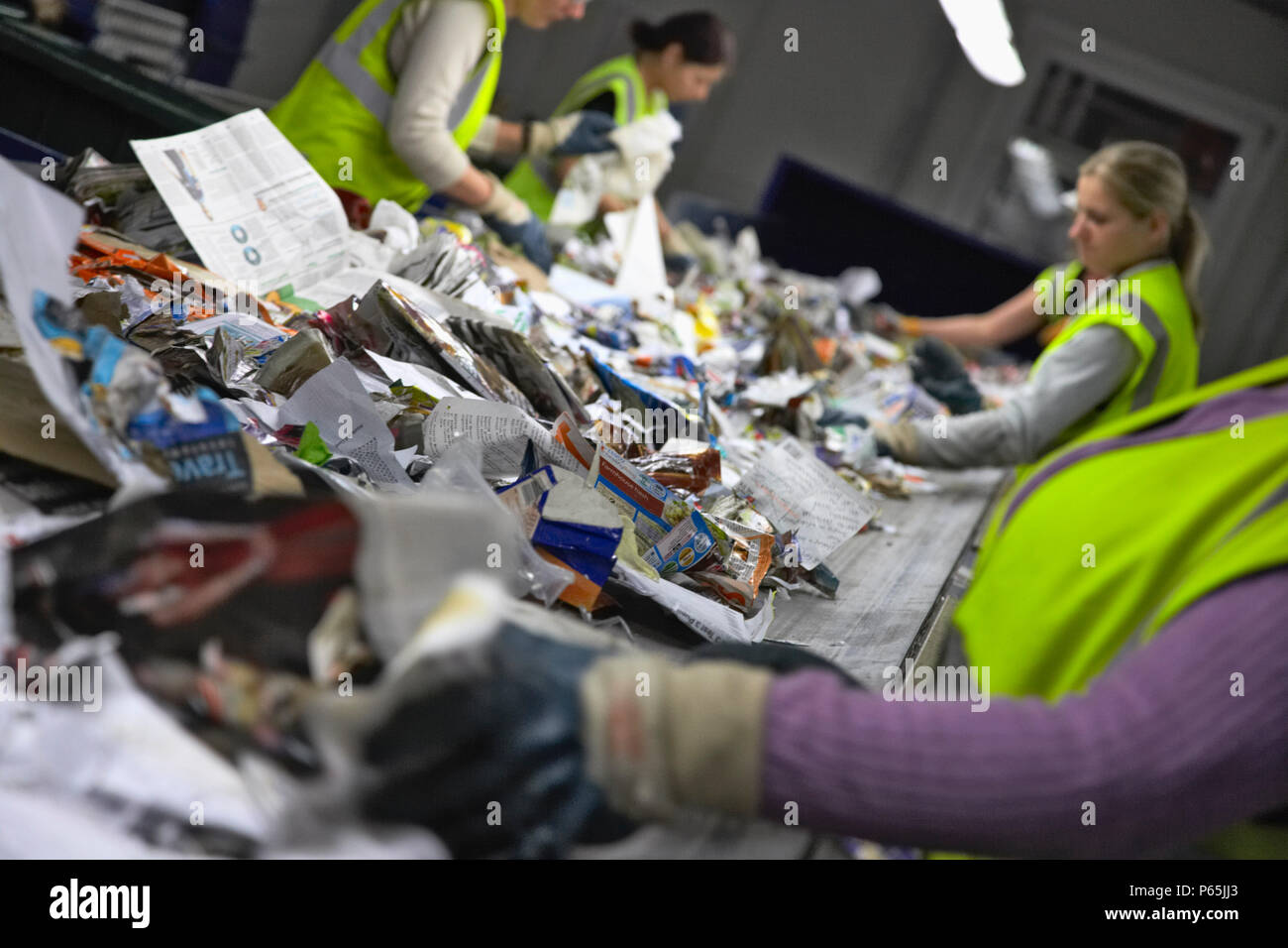Recycling on conveyor belt being sorted at recycling centre Stock Photo