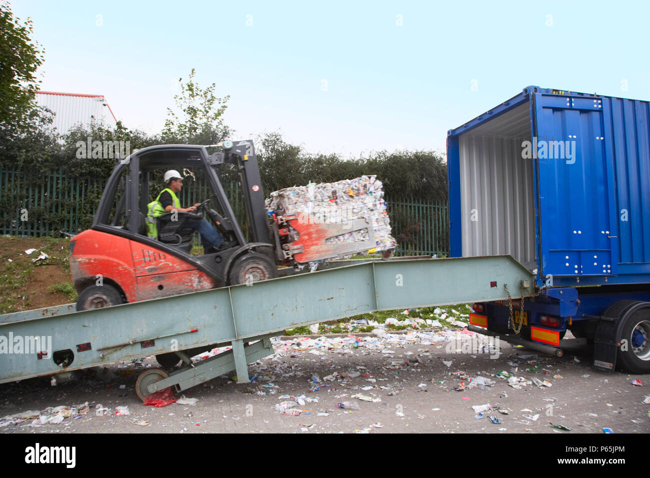 Forklift truck loading compacted recycling on to truck Stock Photo Alamy