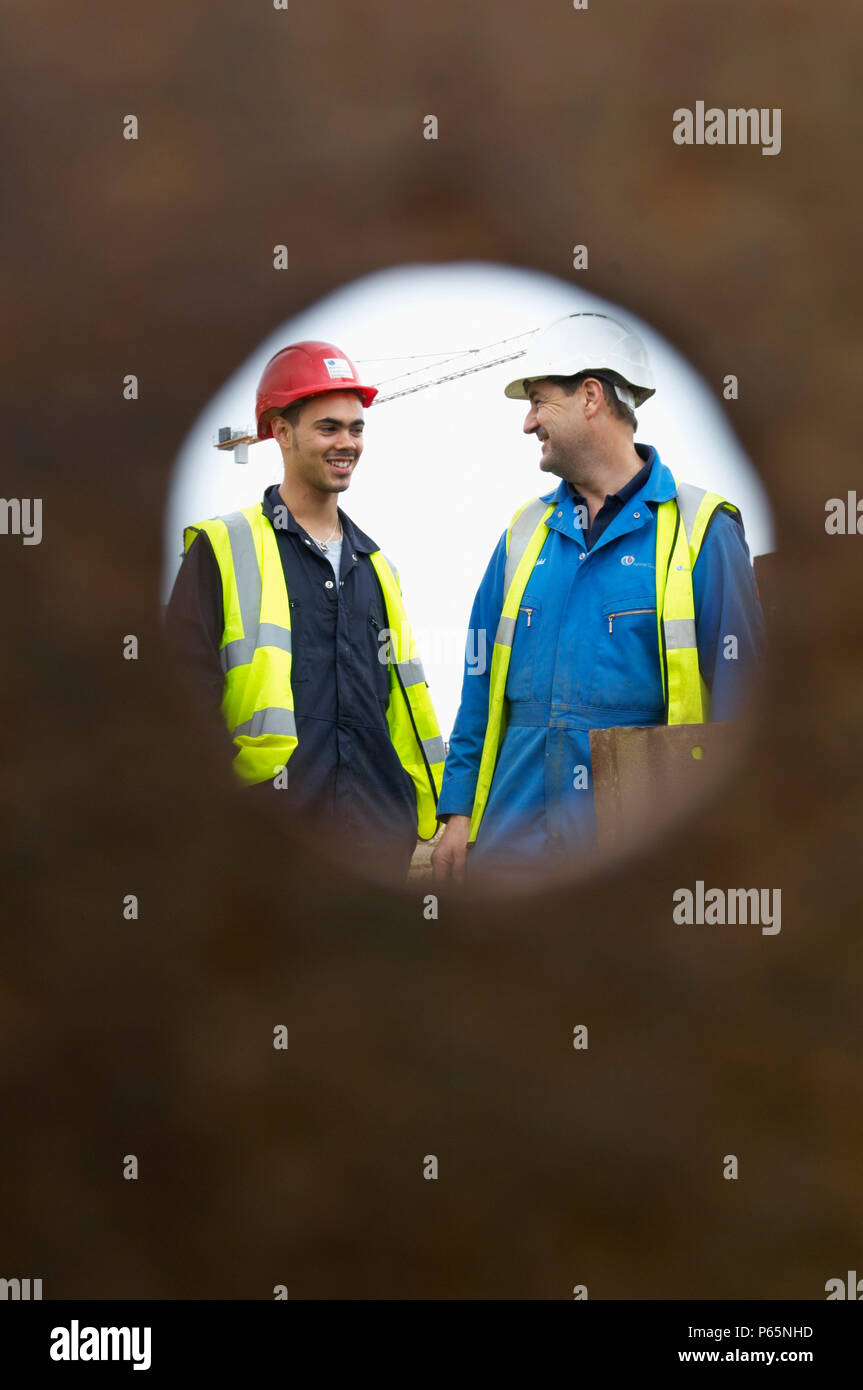 Two construction workers smiling on a building site Stock Photo