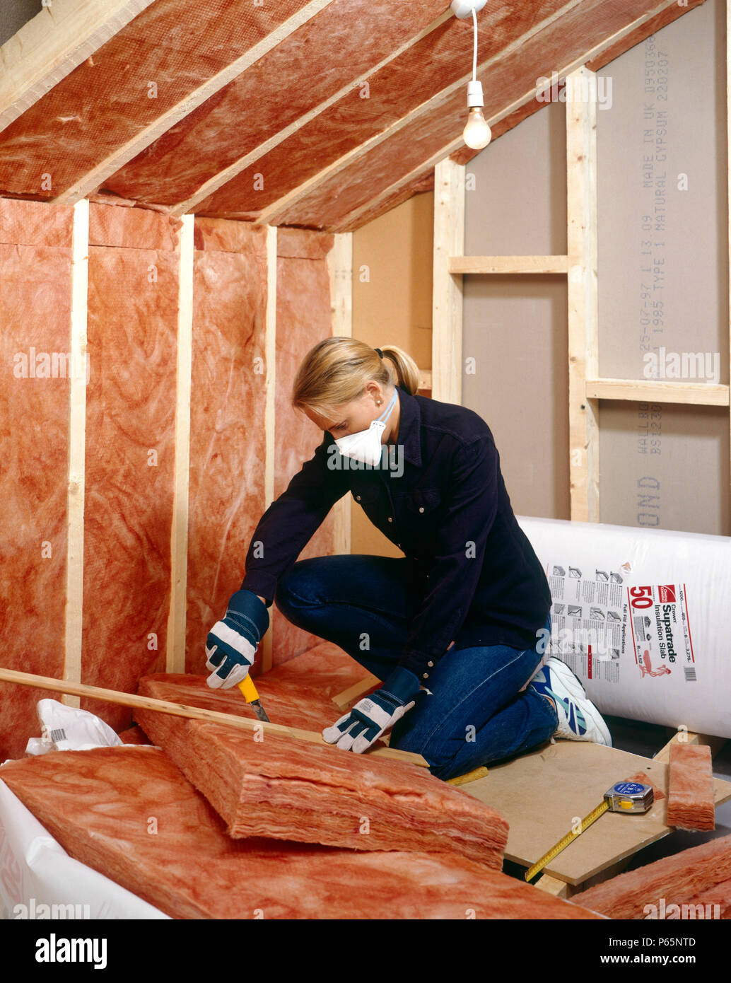 Insulating. Installing quilt loftinsulation to a roof space Stock