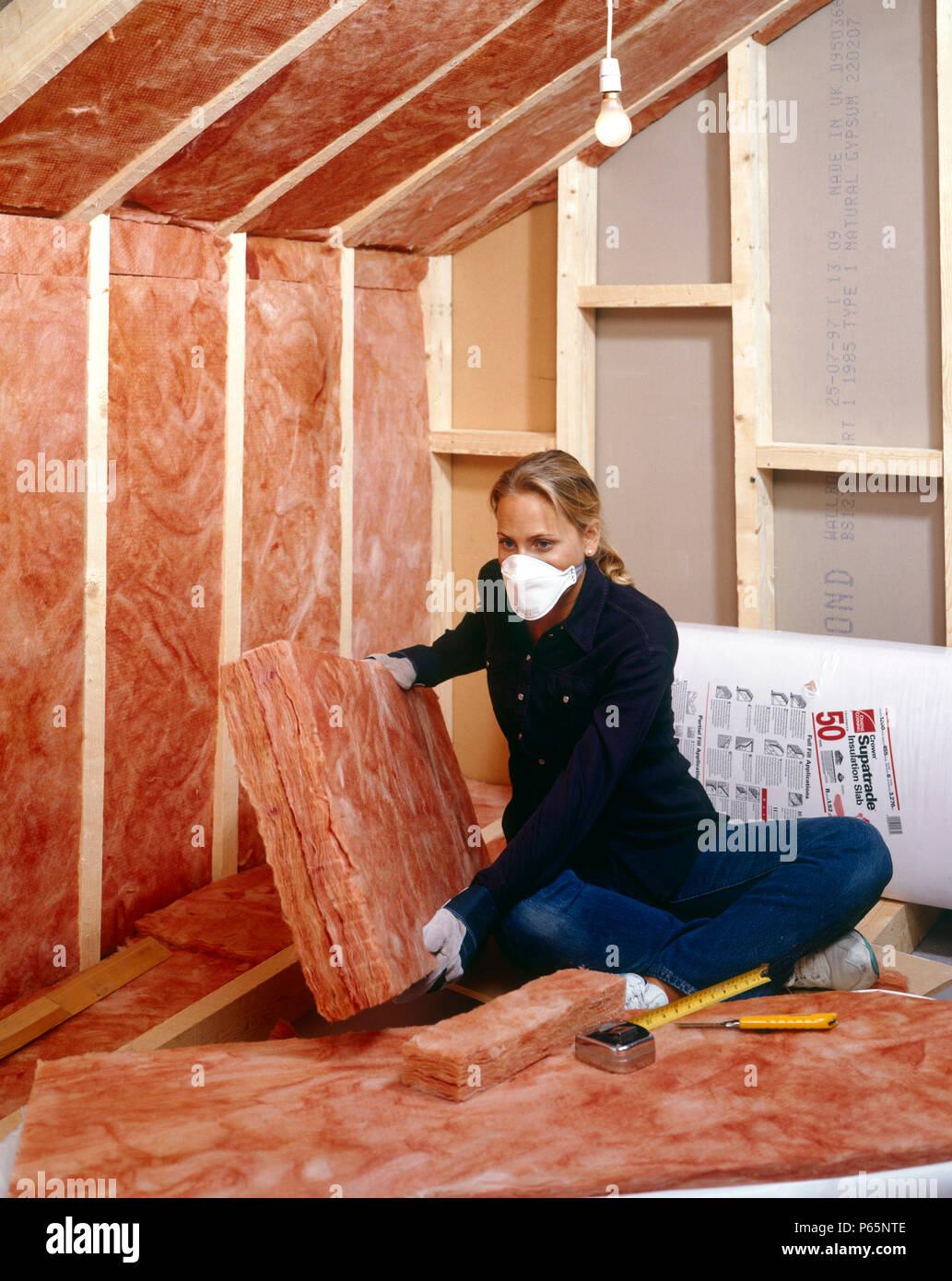 Insulating. Installing quilt loftinsulation to a roof space Stock